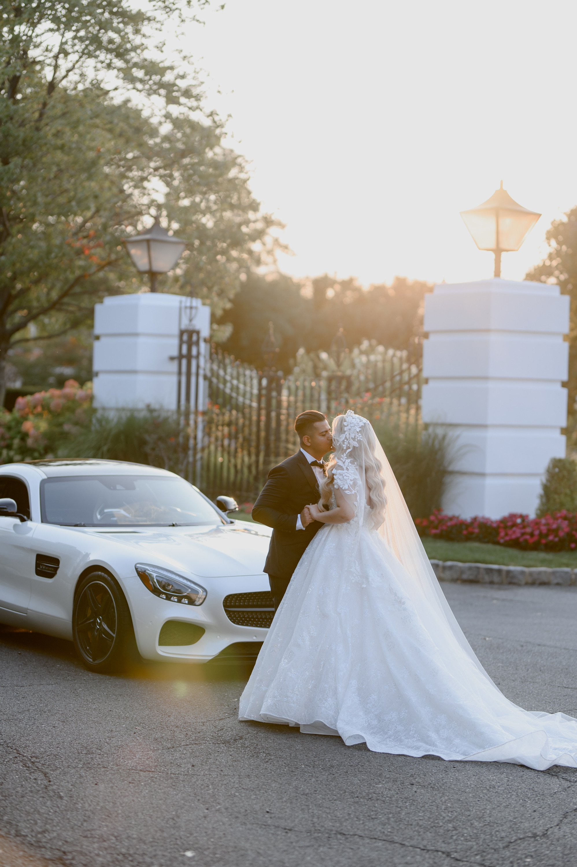 a bride and groom kissing in front of a white car