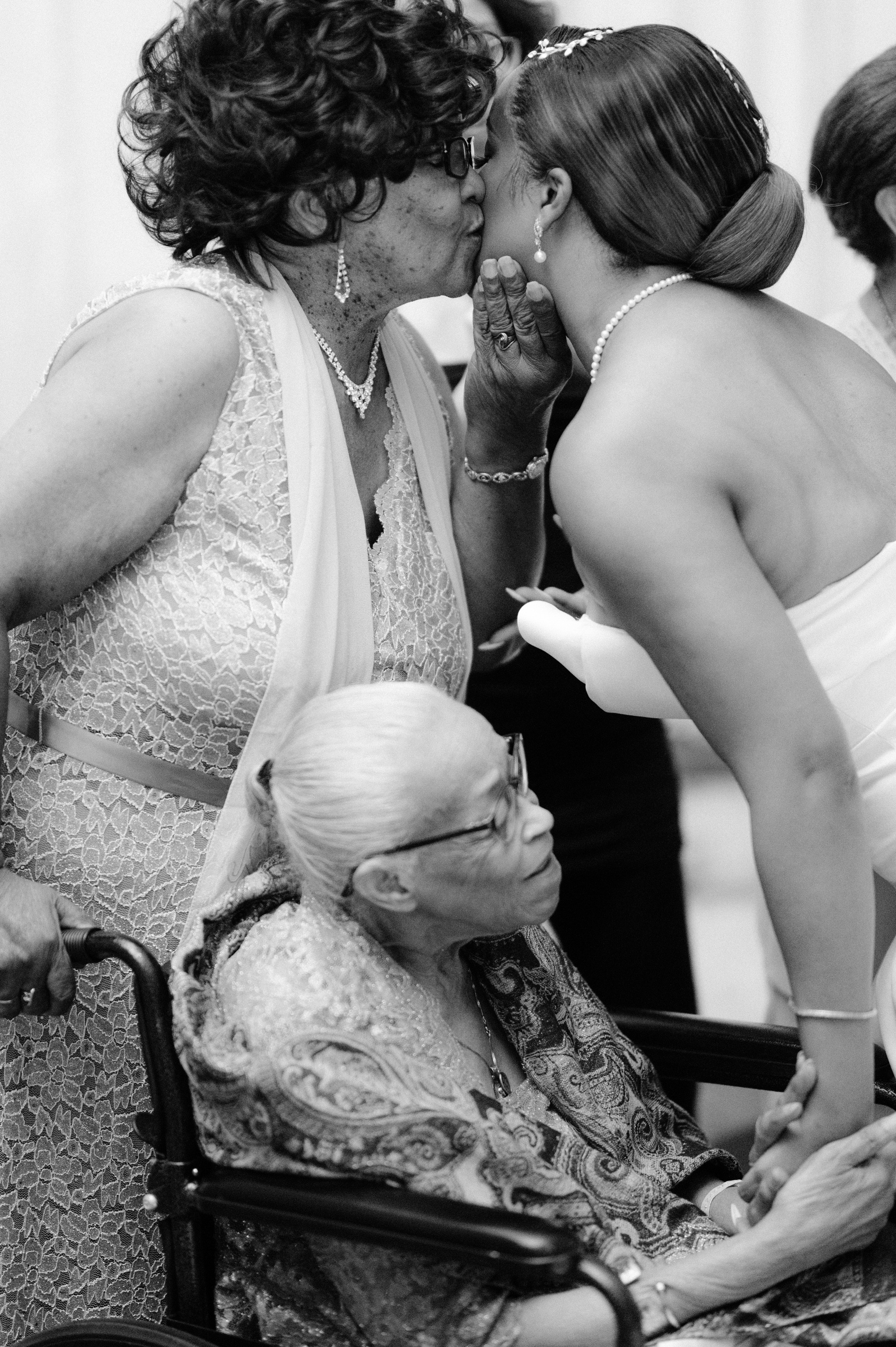 a woman kissing another woman in a wheelchair