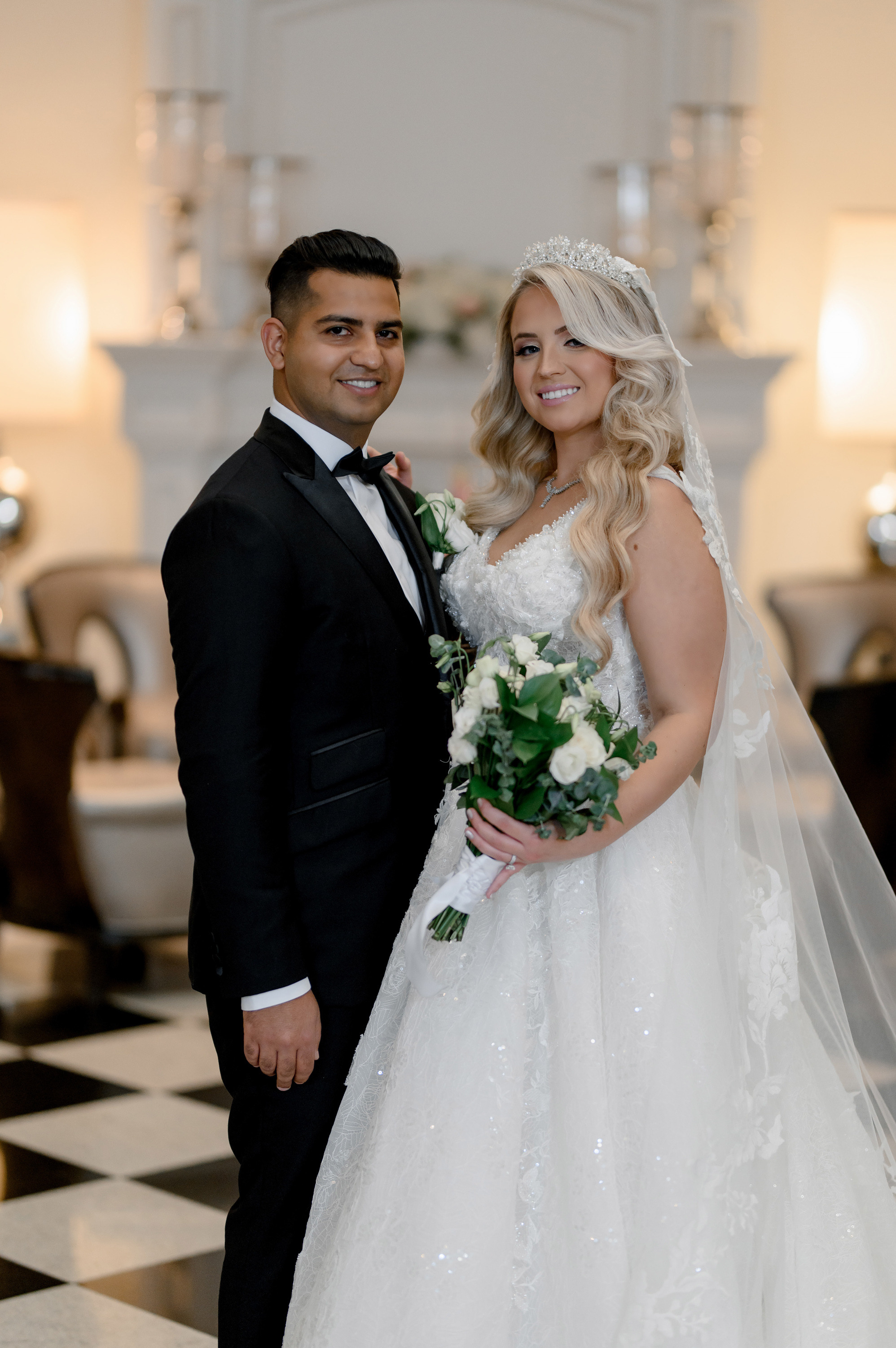 a bride and groom pose for a photo in the lobby