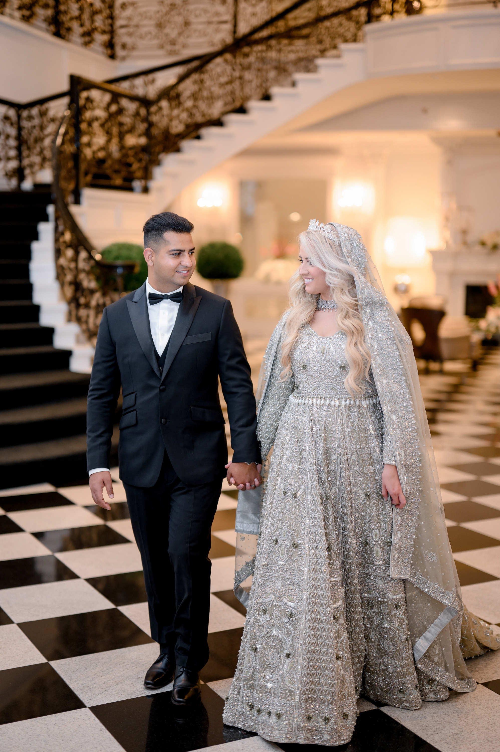 a bride and groom walking down the stairs at their wedding