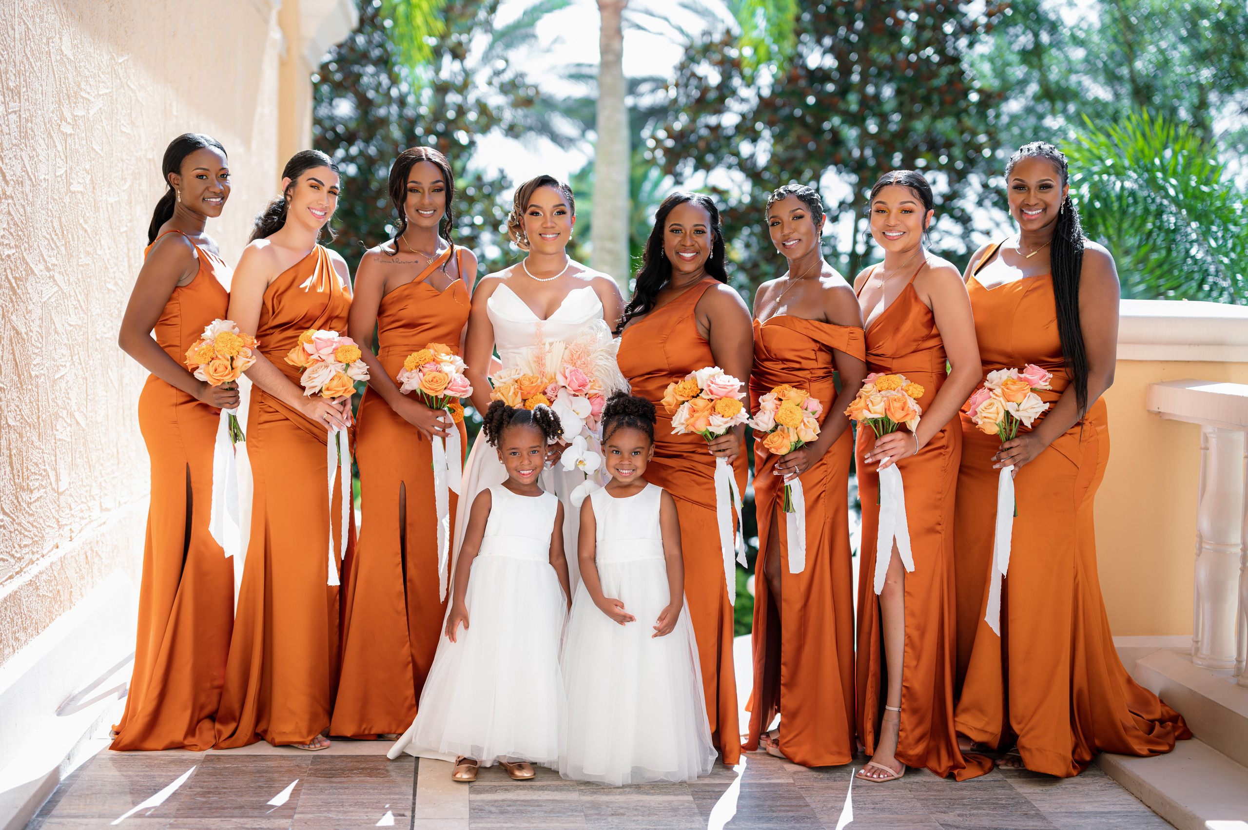 a group of women in orange dresses posing for a picture