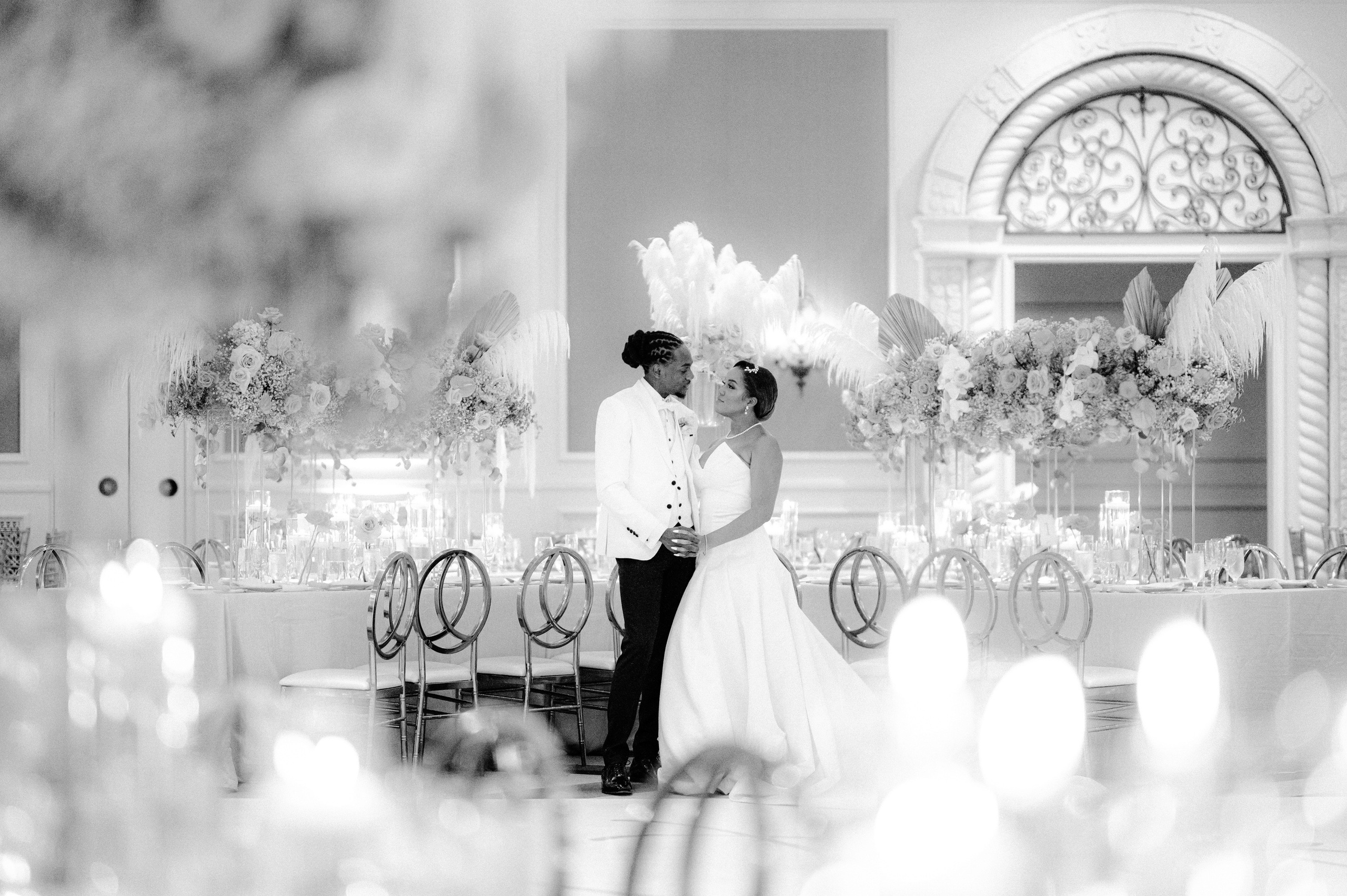 a bride and groom kissing in front of a table