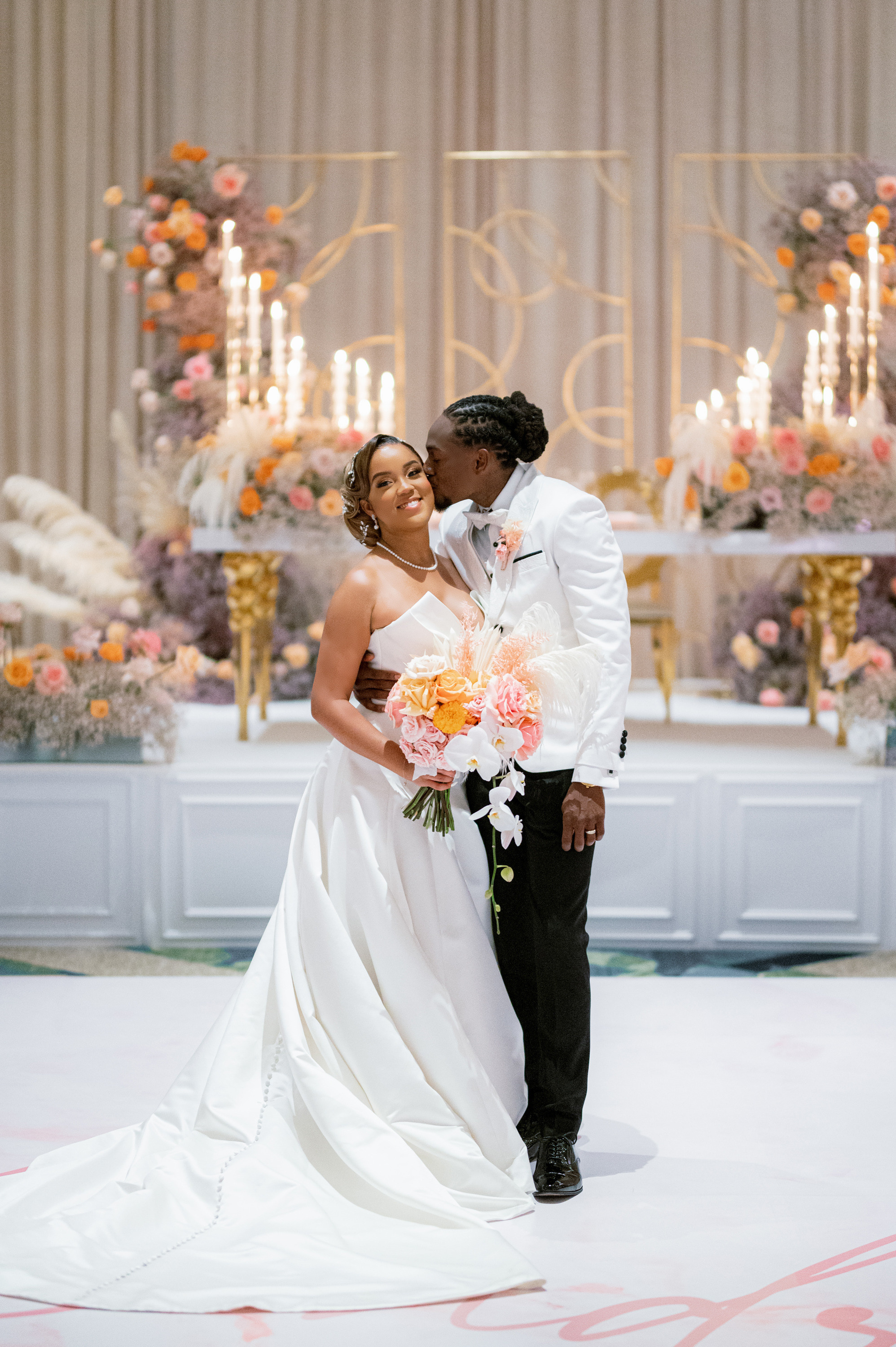 a bride and groom kissing in front of a wedding altar