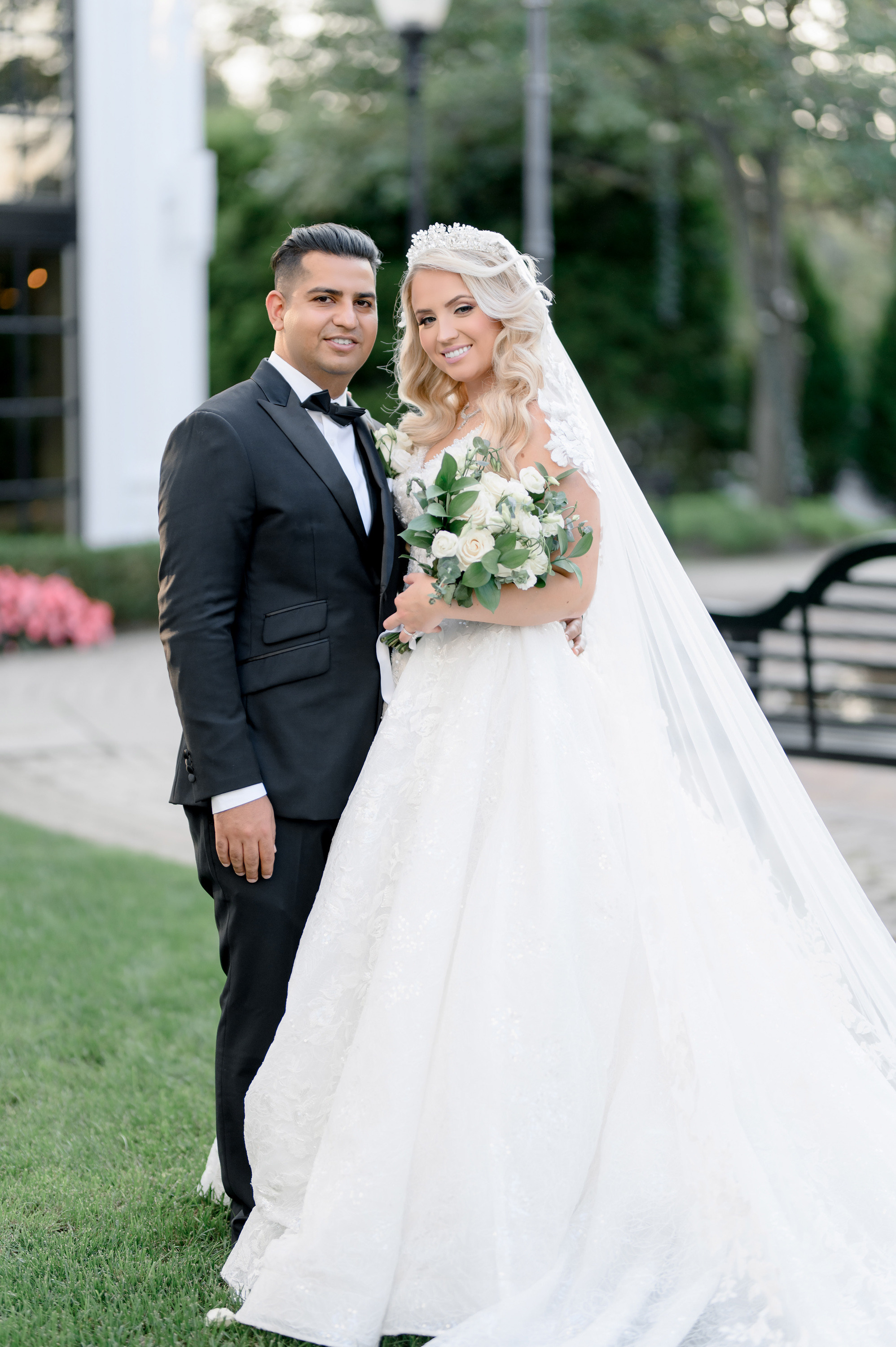 a bride and groom pose for a photo in front of the hotel