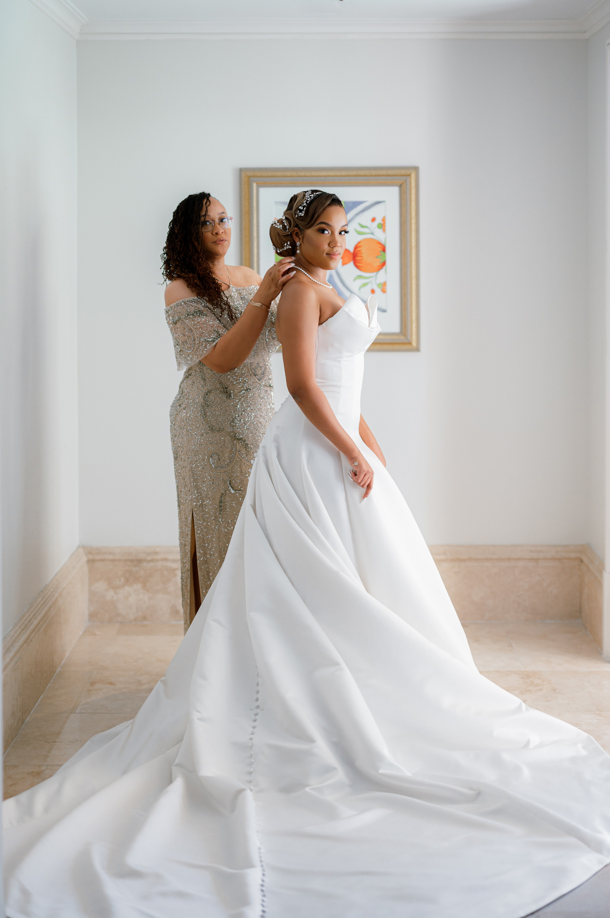 a woman in a wedding dress is helping another woman with her dress