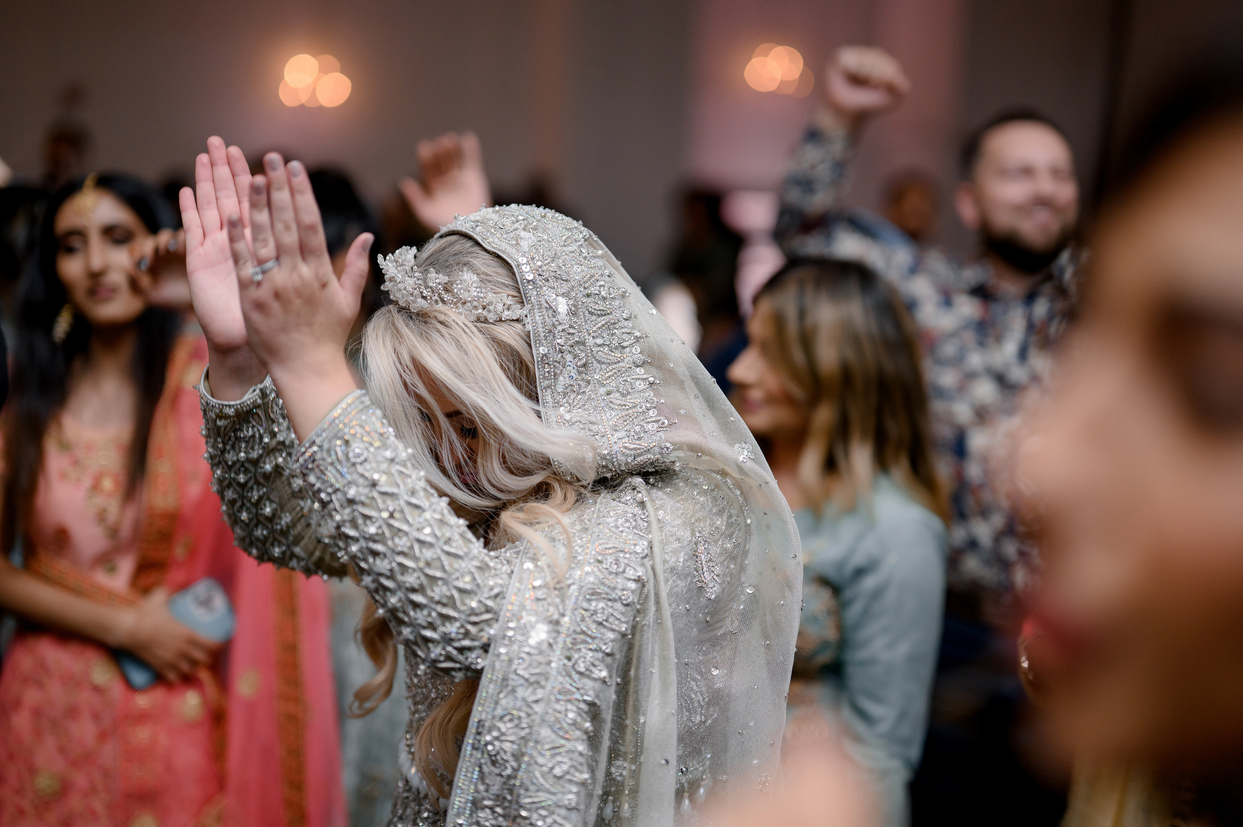 a woman in a white dress is standing in a crowd