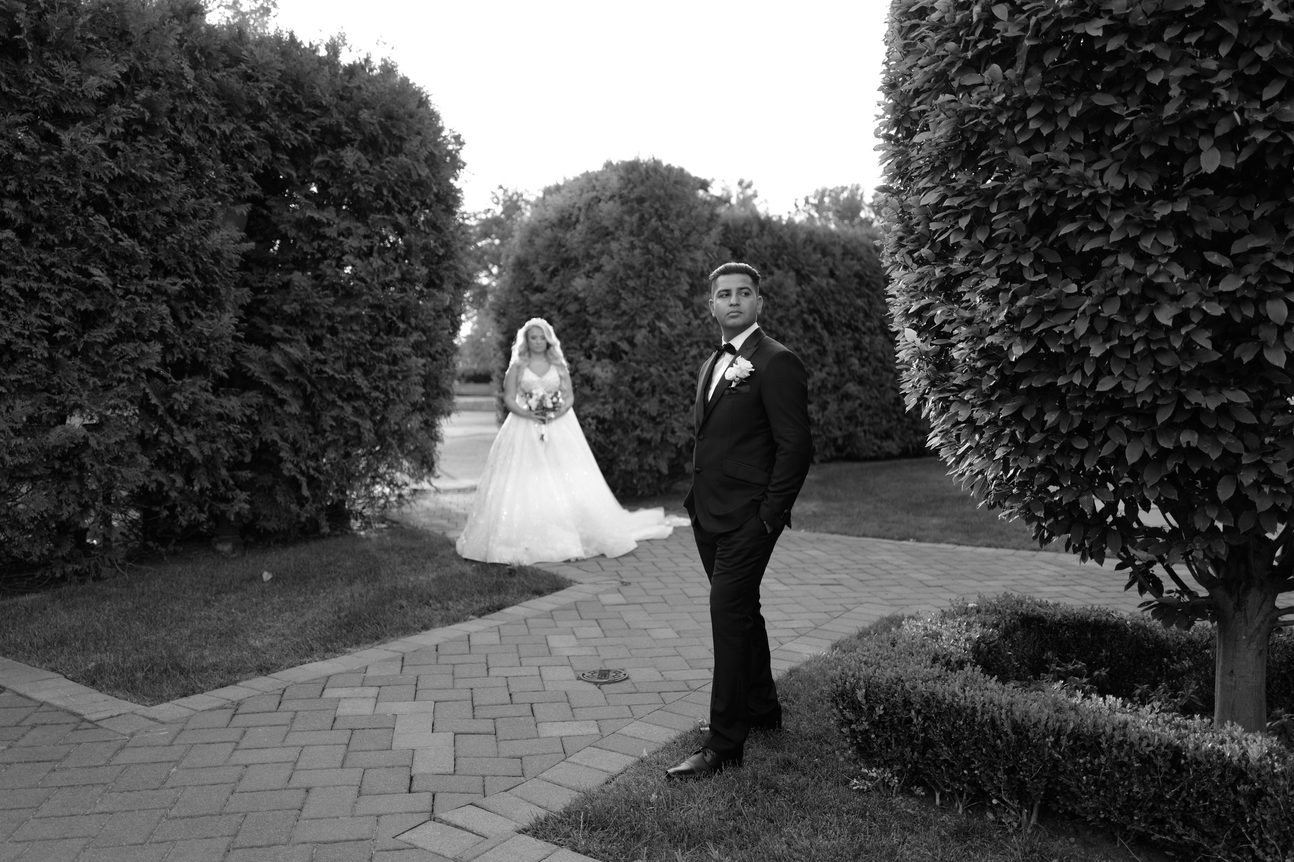 a bride and groom walking through the garden