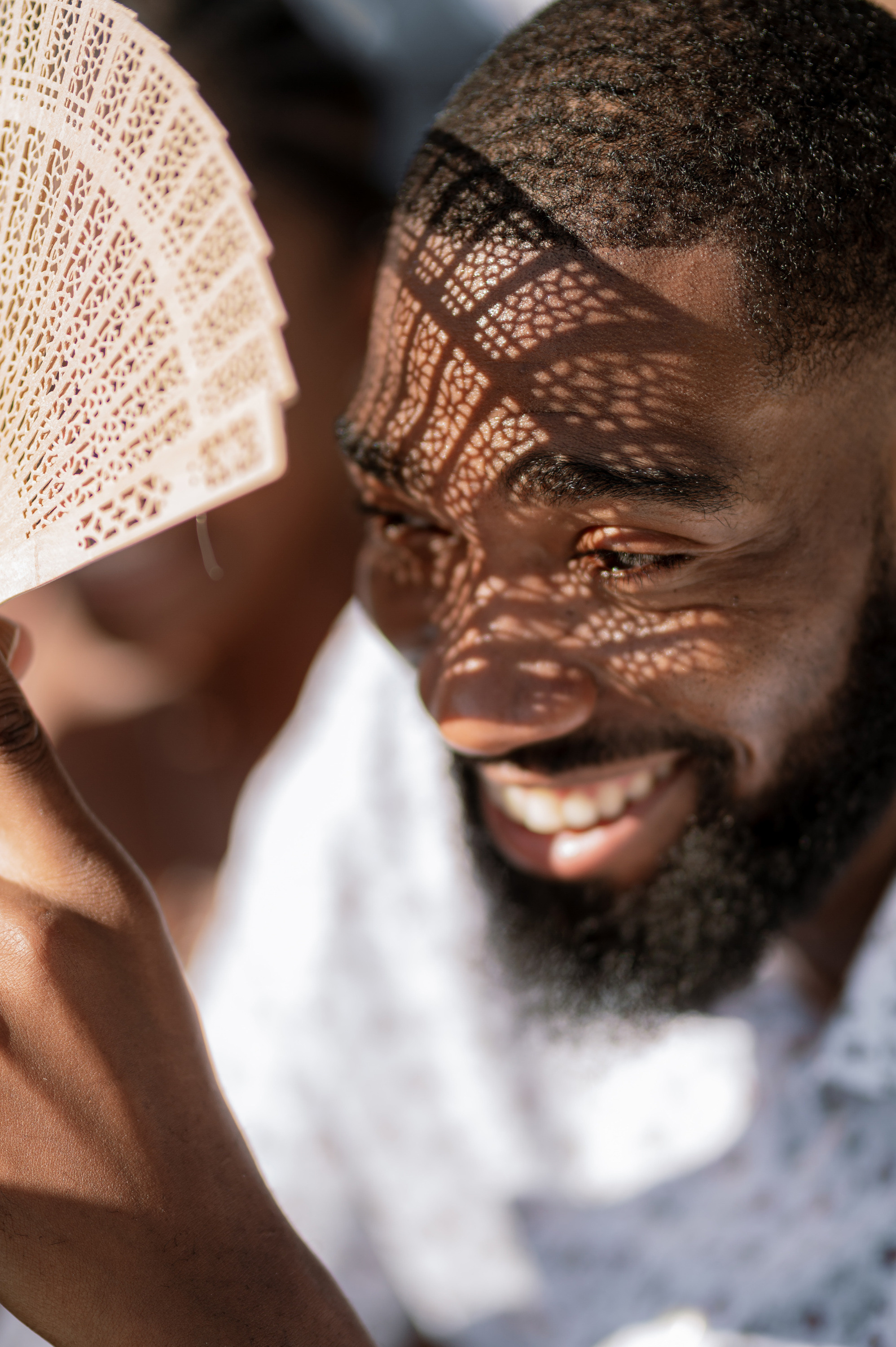 a man holding a fan with a smile on his face
