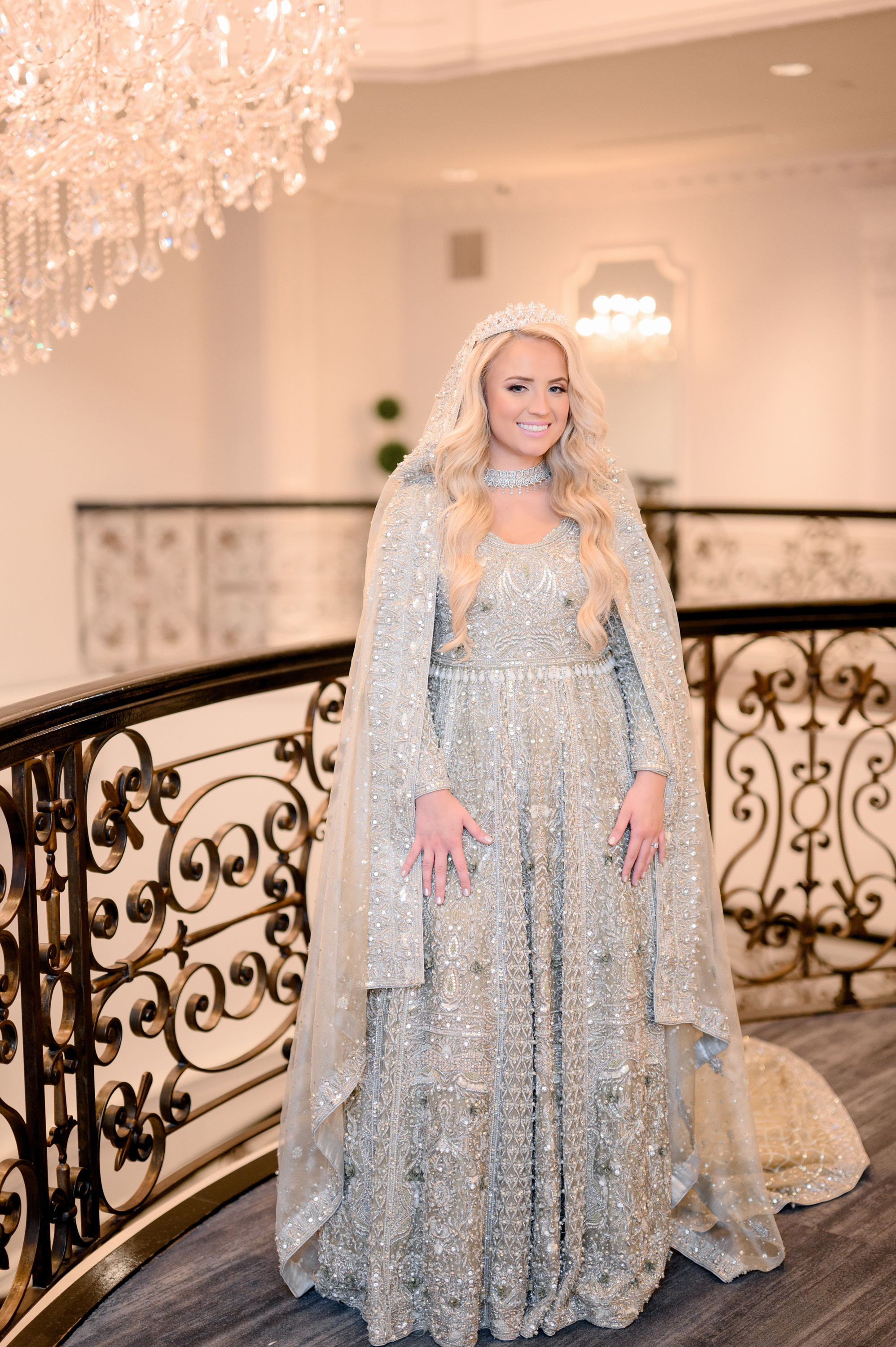 a woman in a silver gown and a white cape