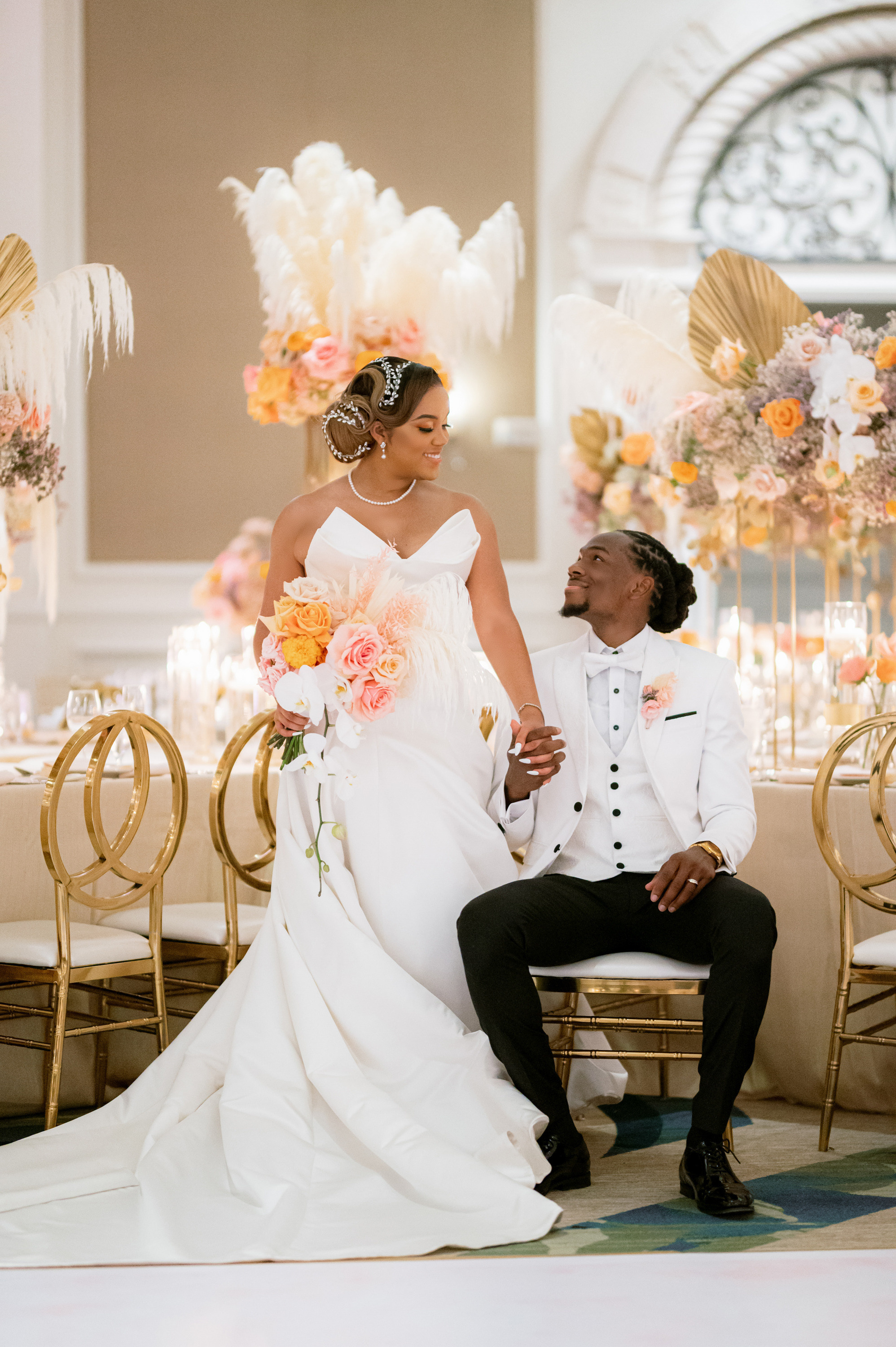 a bride and groom sitting on a chair