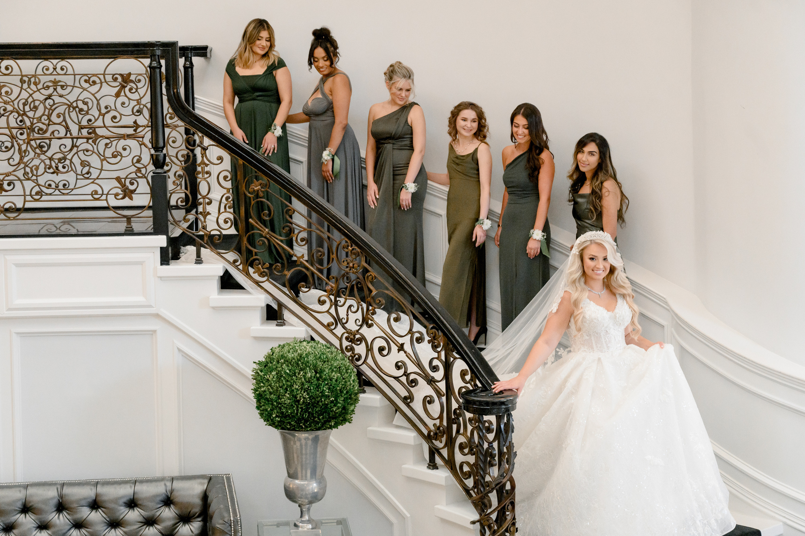 a bride and her bridesmaids on the stairs