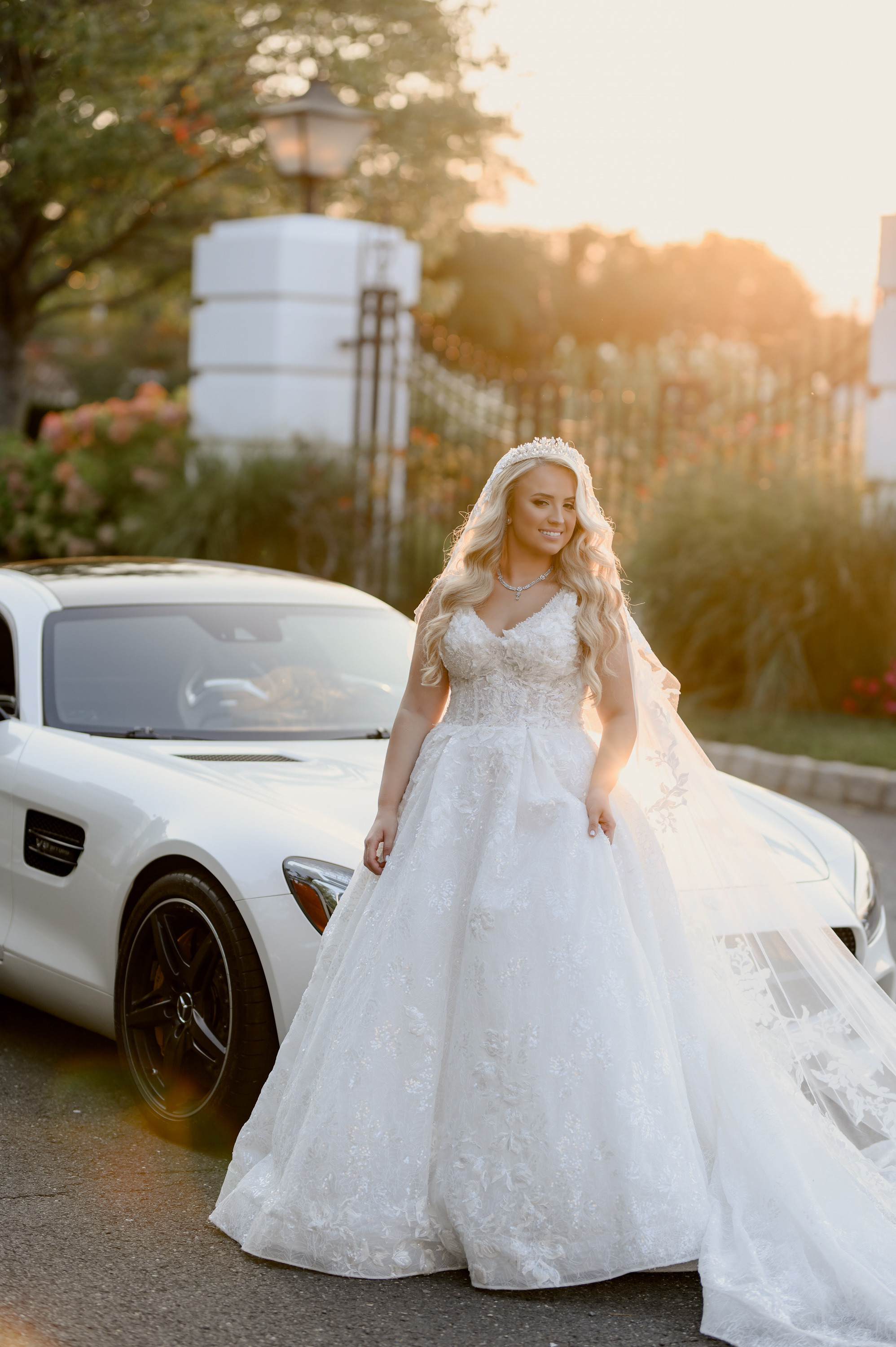 a woman in a wedding dress standing next to a white car