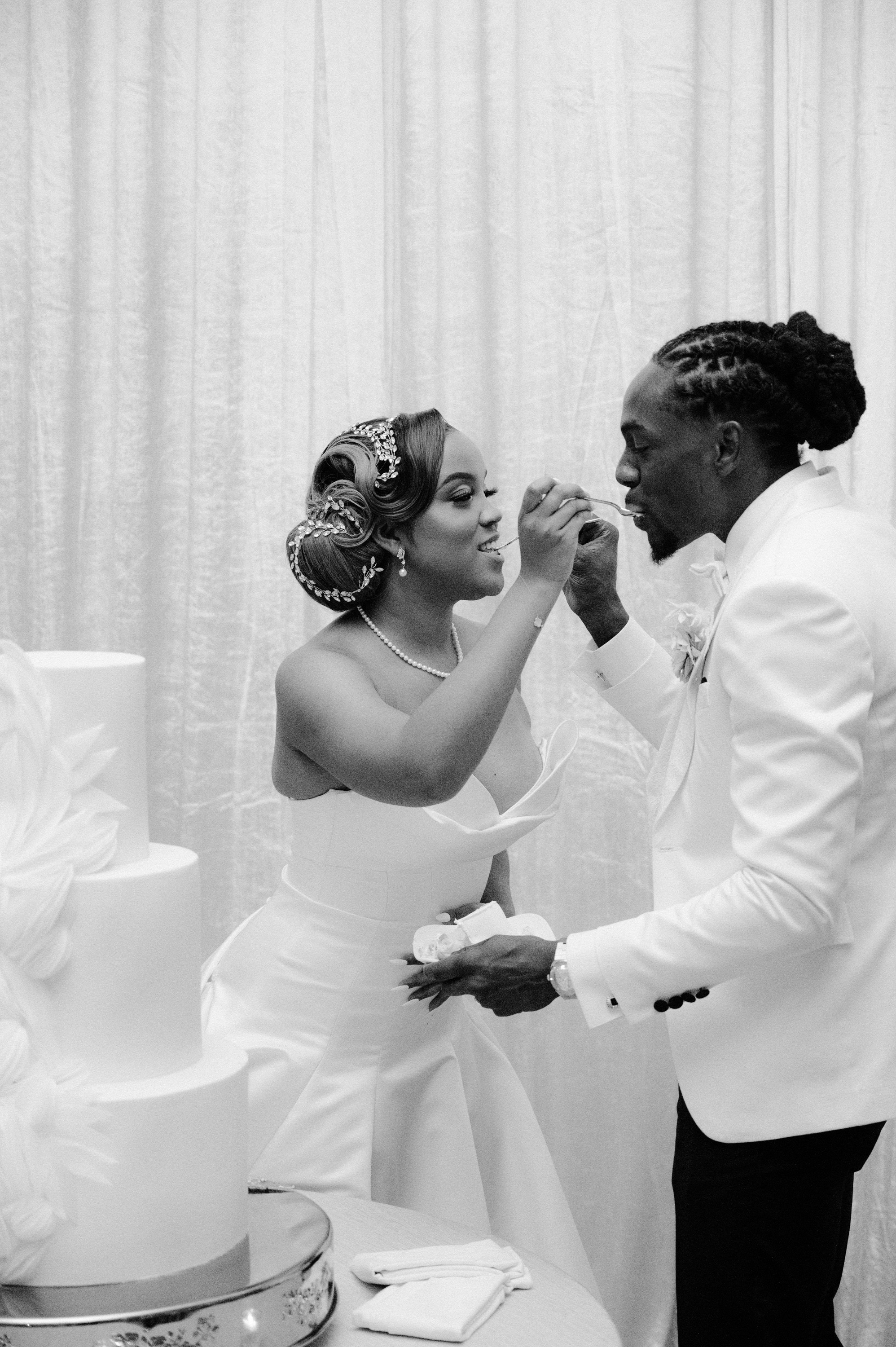 a man and woman are cutting into a cake