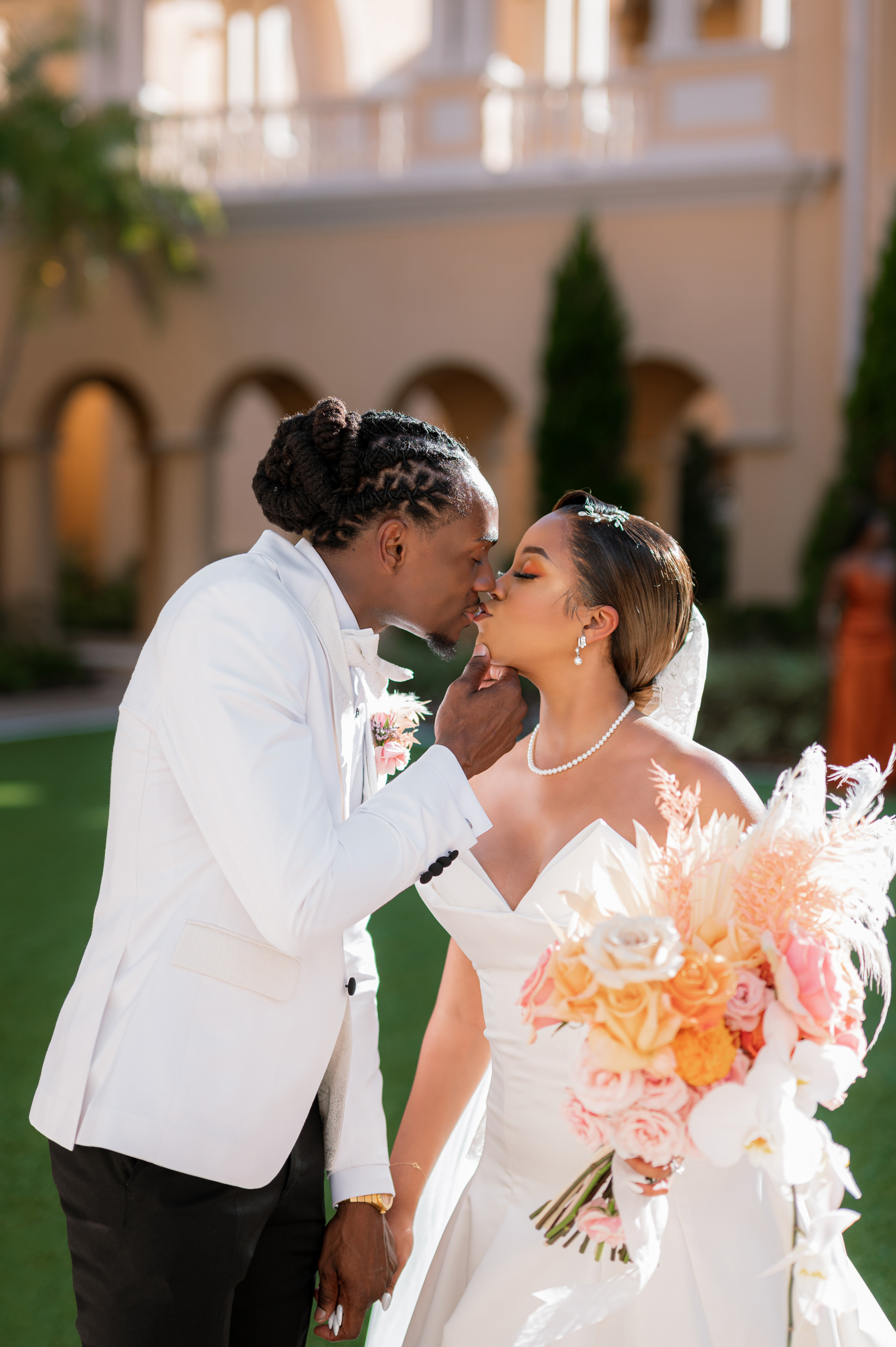 a bride and groom kissing in front of a large building