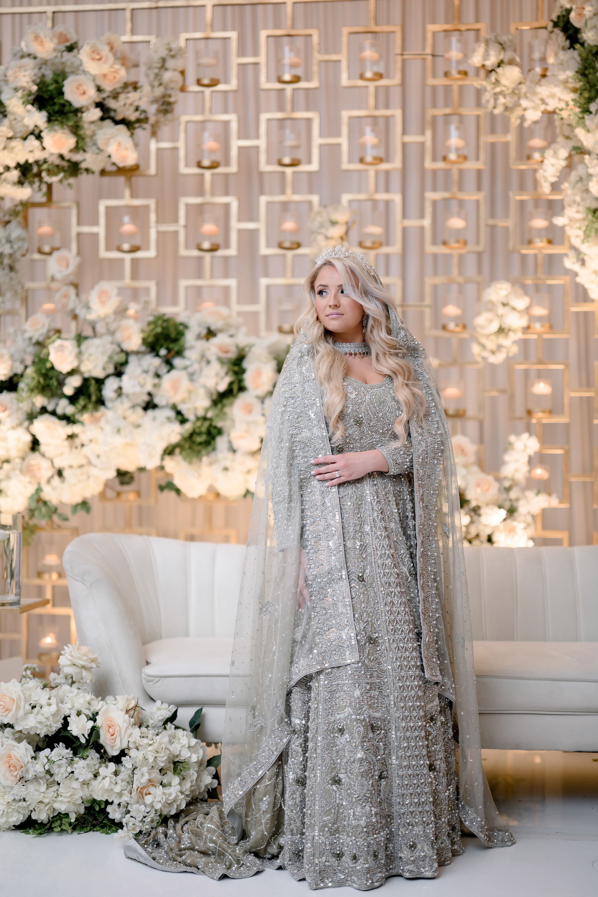 a woman in a silver gown and a white floral arrangement