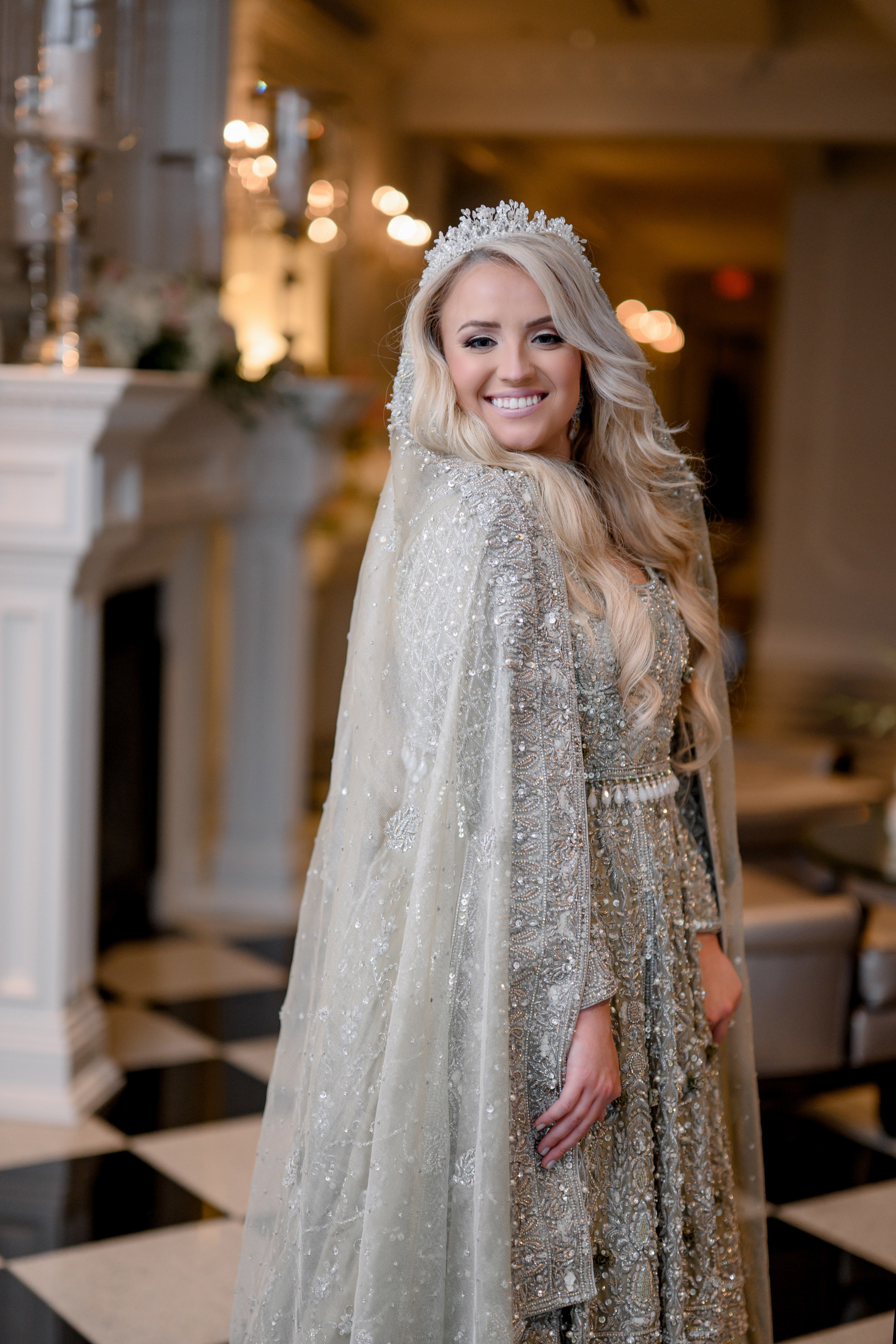 a woman in a silver cape with a white veil and a tia