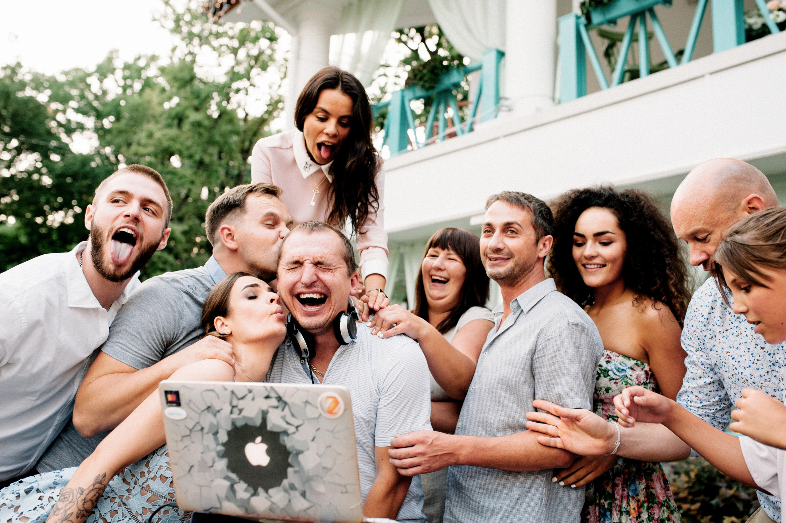 a group of people standing around a laptop