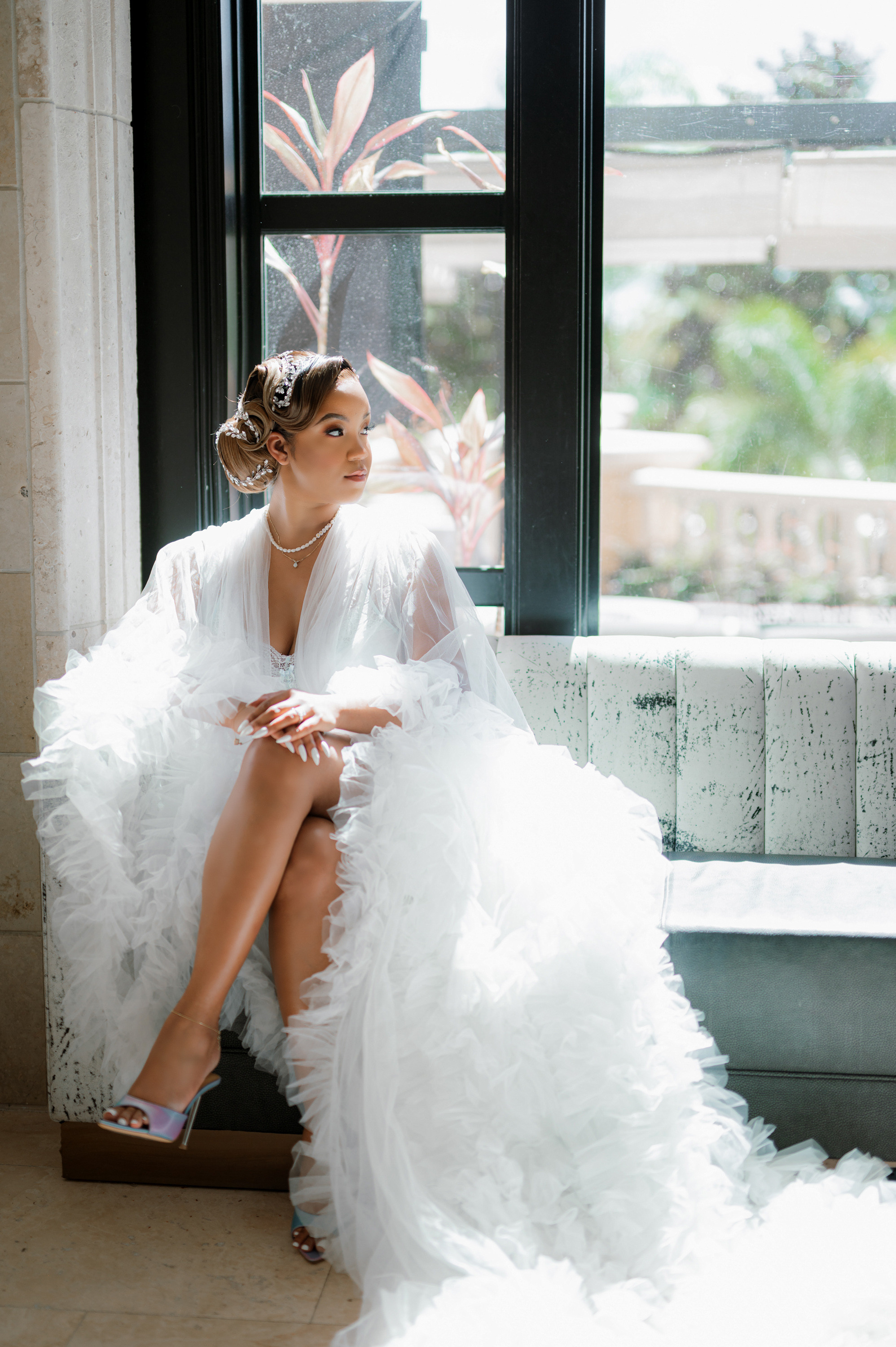 a woman in a white dress sitting on a window sie