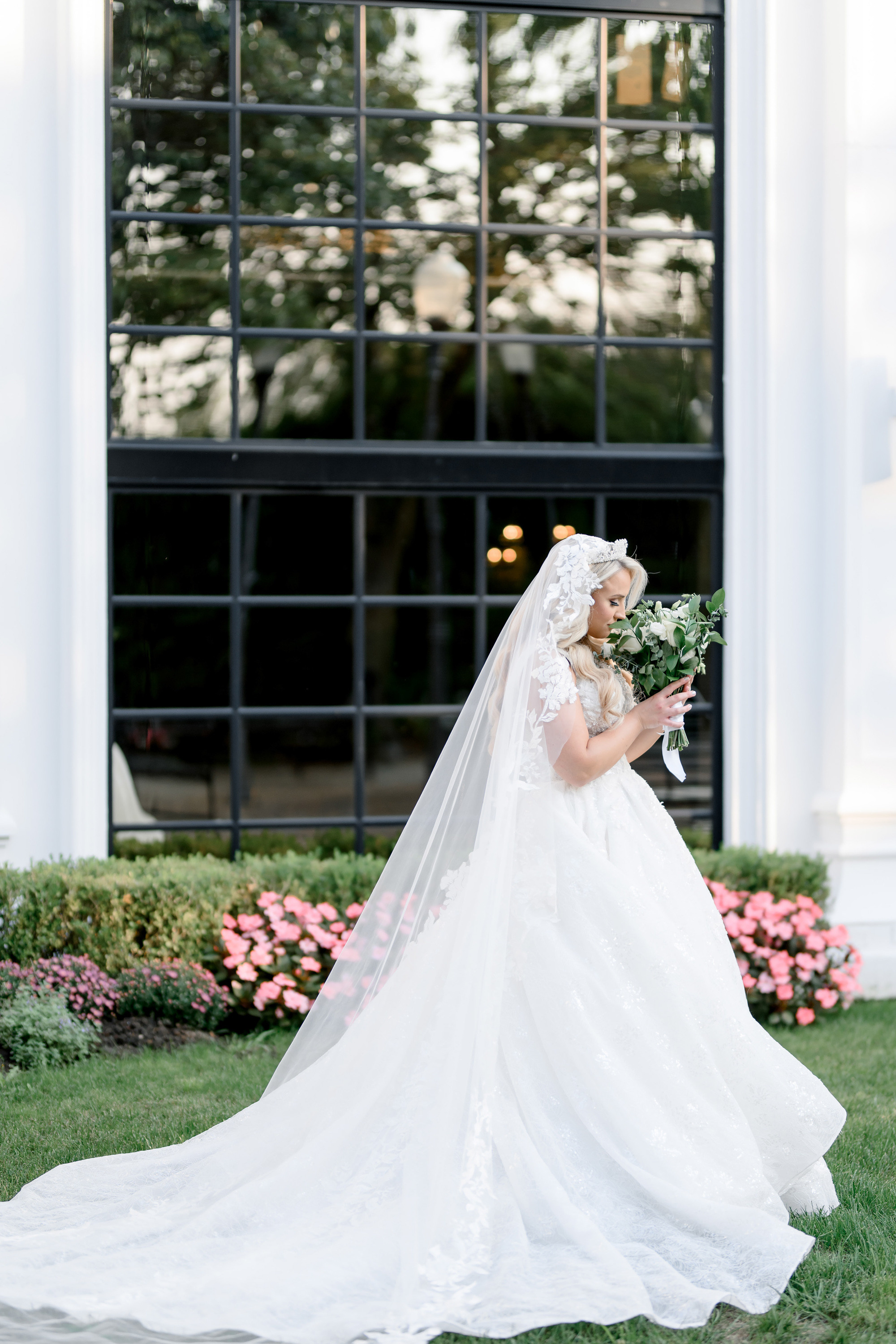 a bride in a wedding dress and veil walking through the grass
