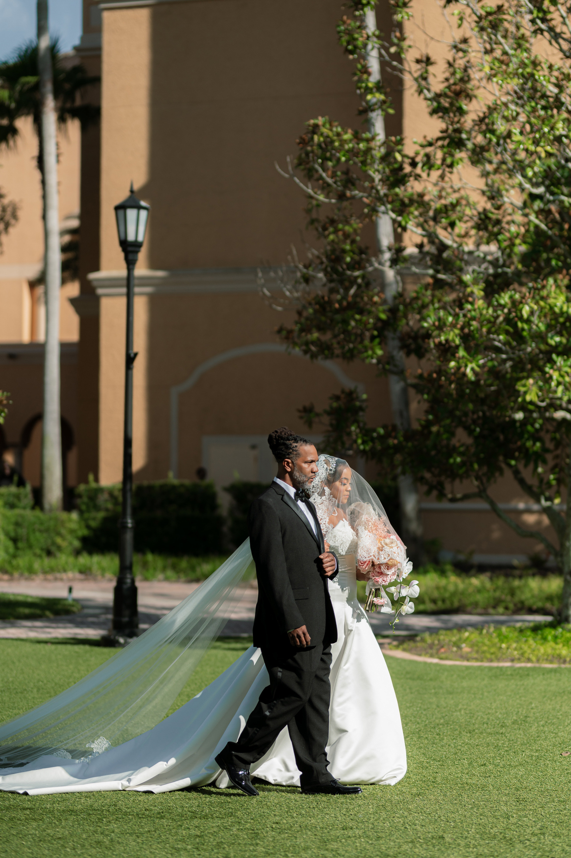a bride and groom walking in the grass