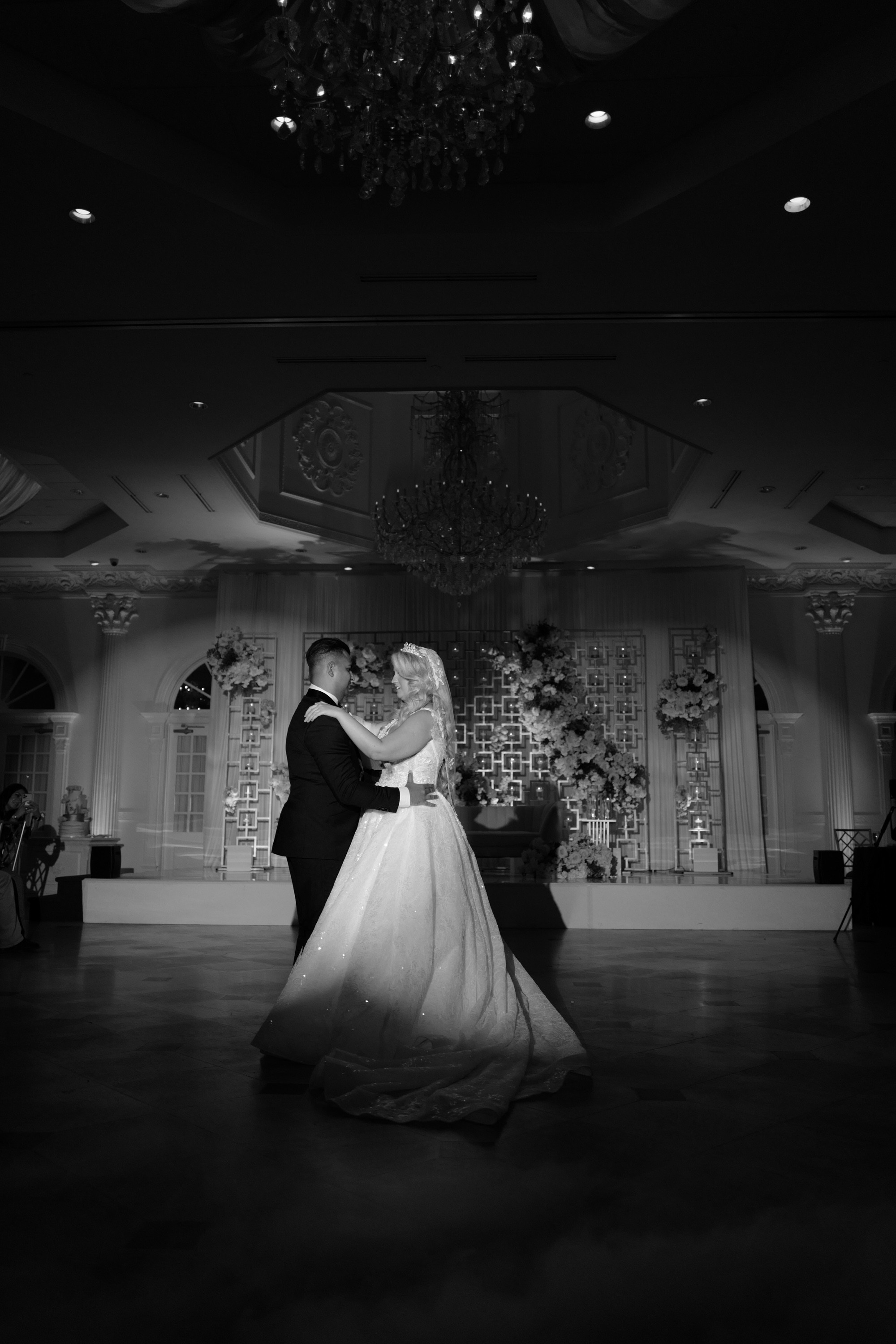 a bride and groom dance in the ballroom