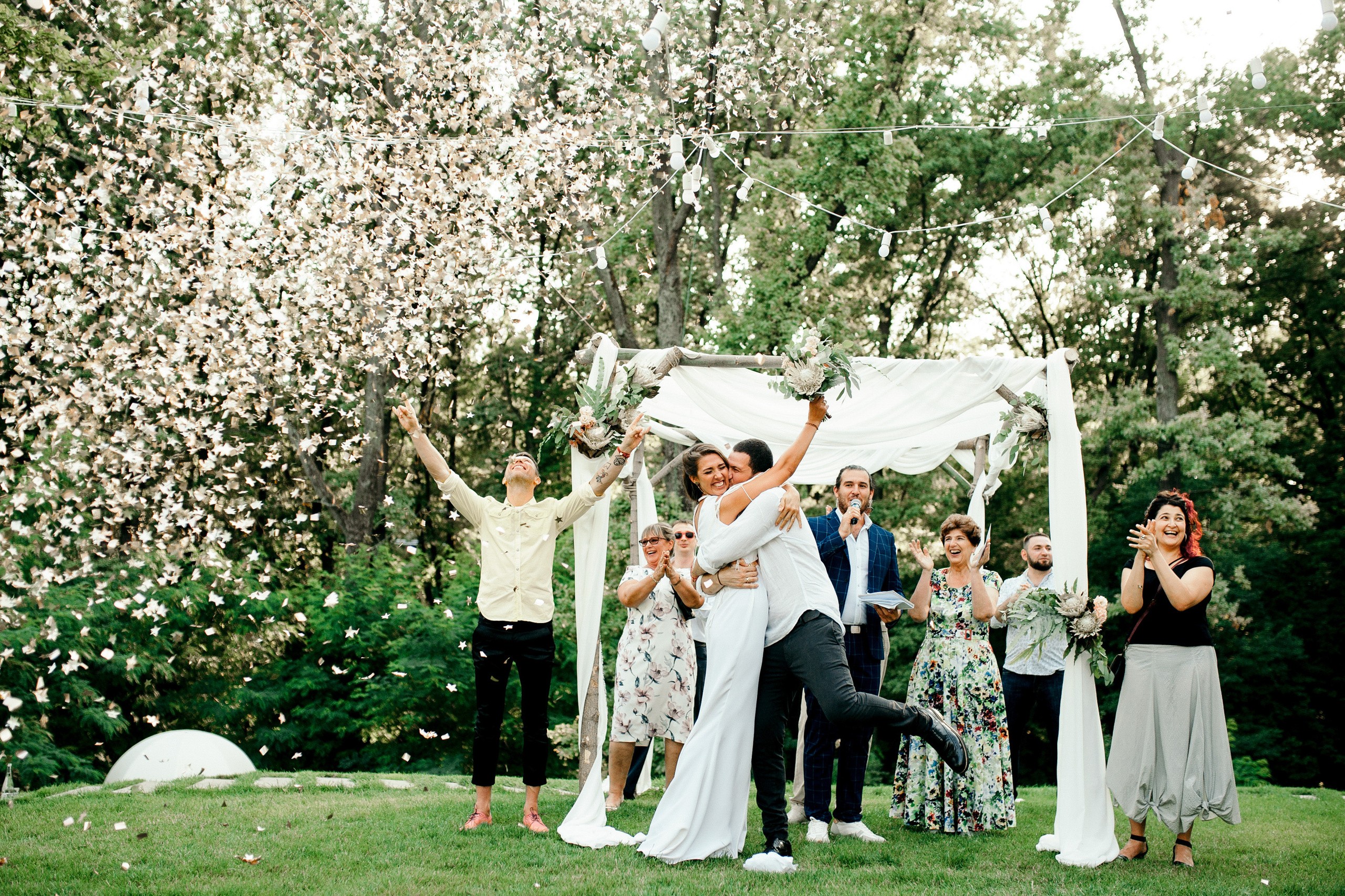 a group of people standing around a white canopy