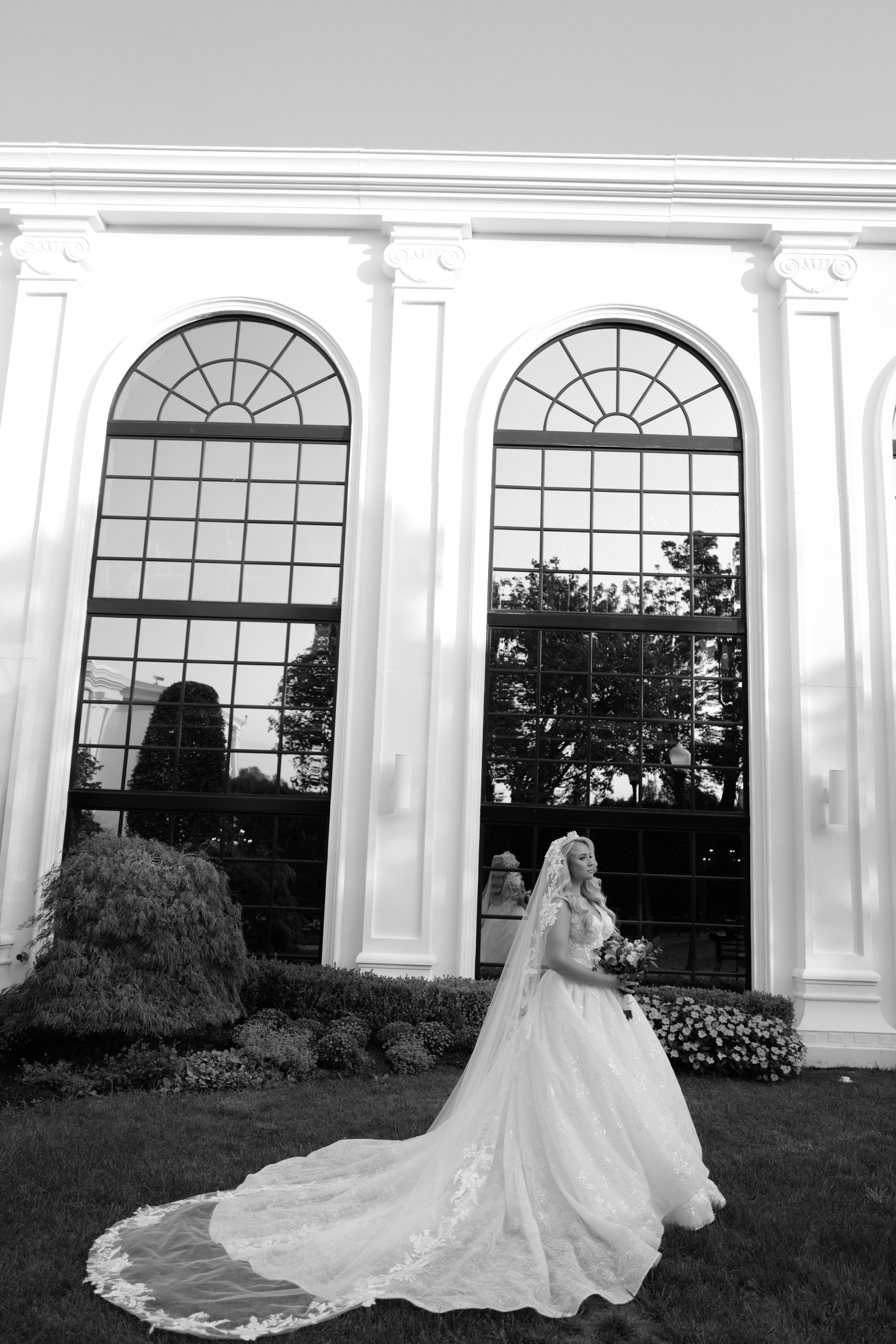 a bride poses in front of a large white building