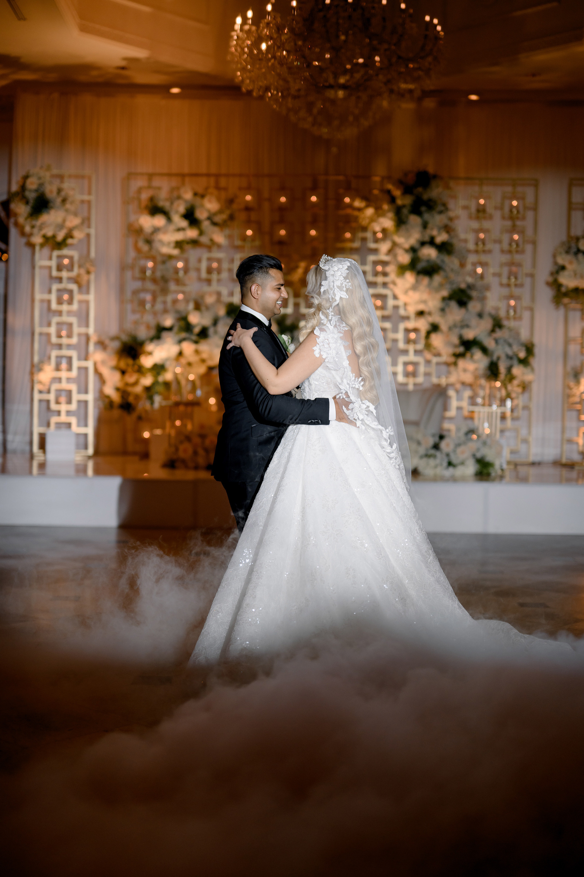 a bride and groom are kissing in the fog