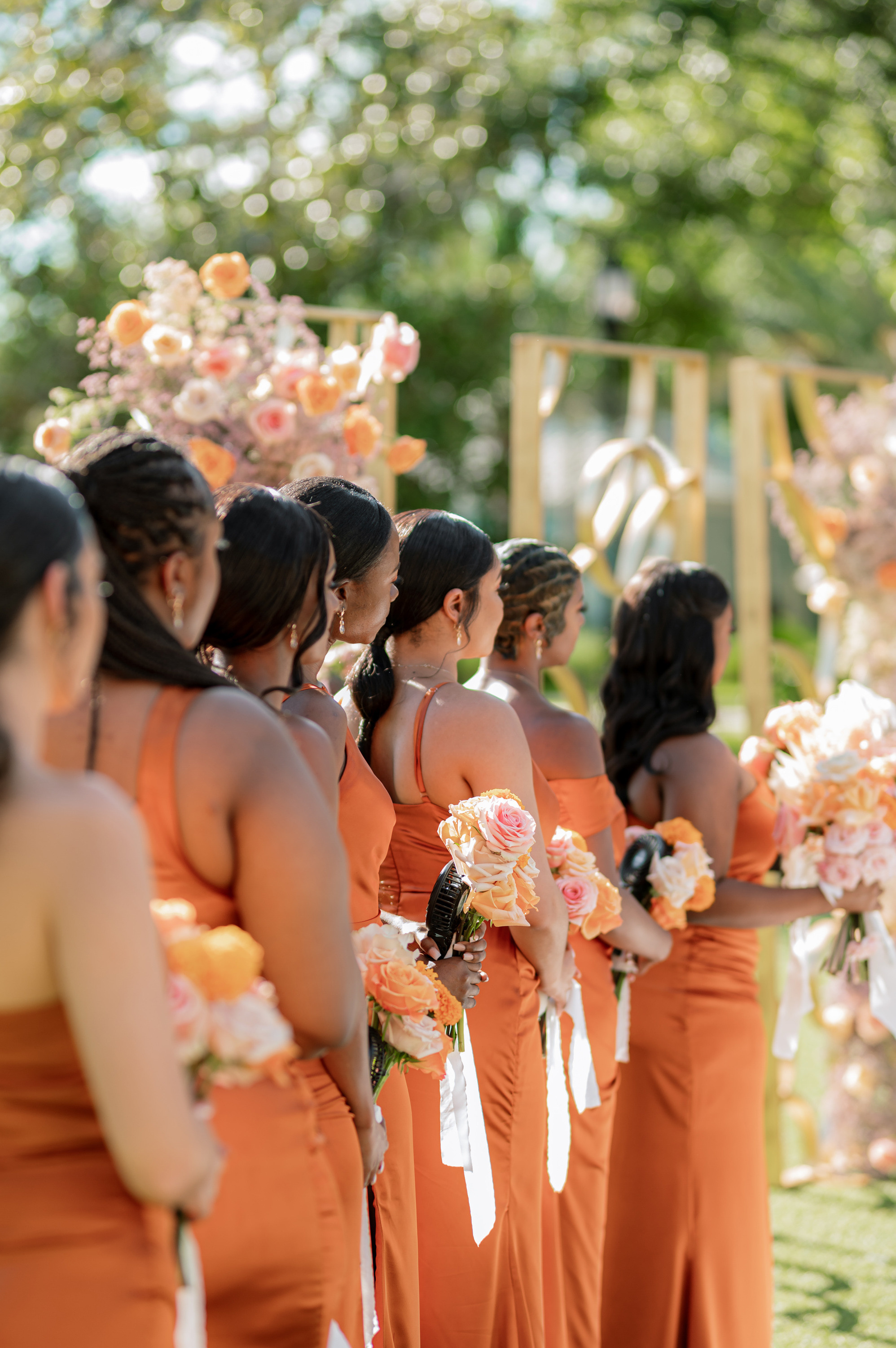 a group of women in orange dresses standing in a line