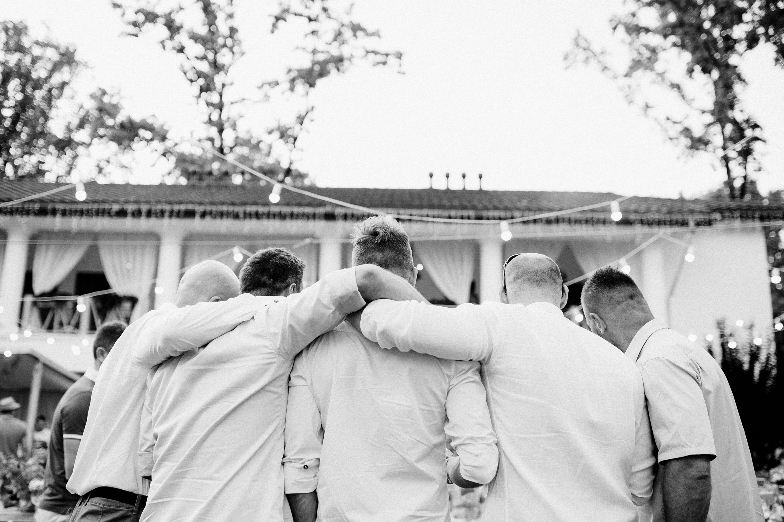 a group of men standing around each other men