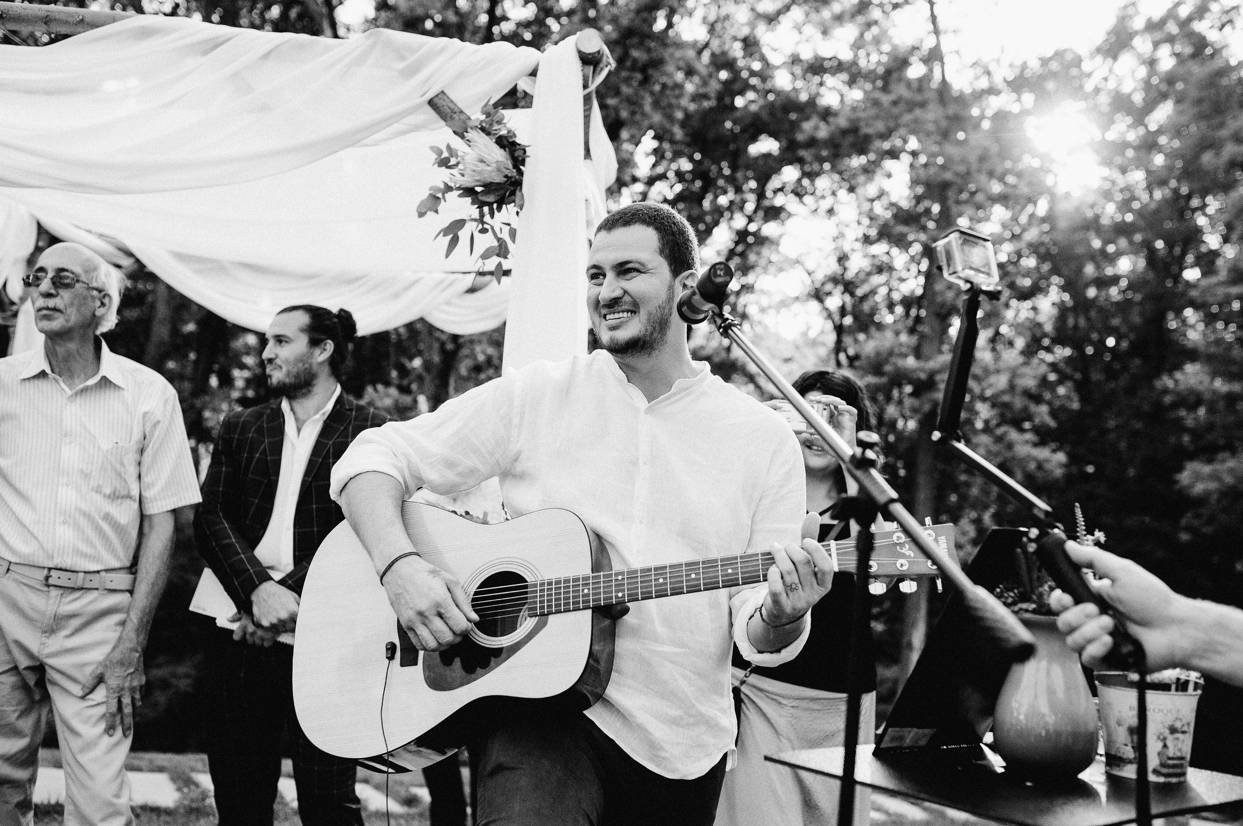 a man playing guitar and singing into a microphone