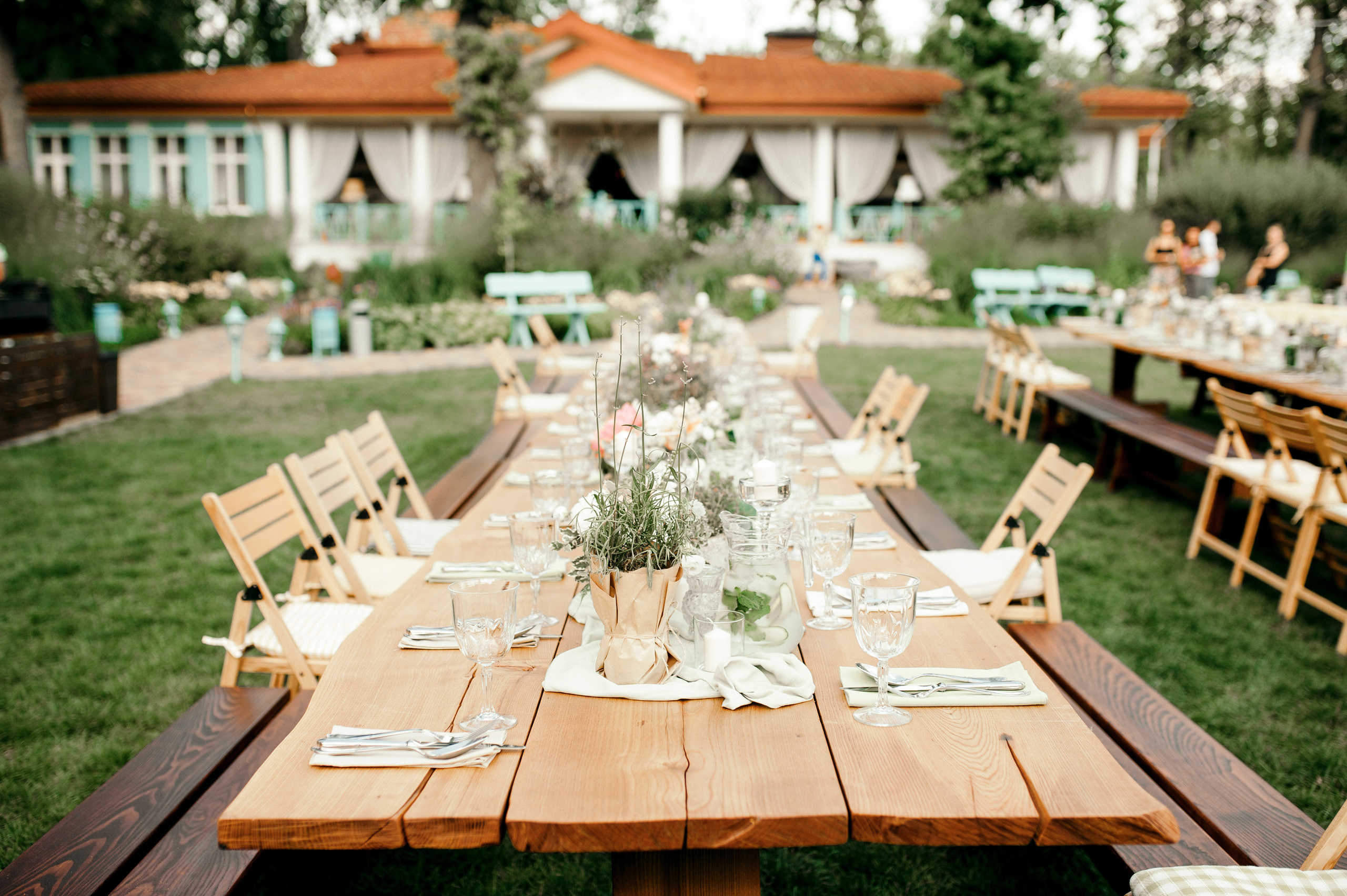 a long wooden table with a vase of flowers on it
