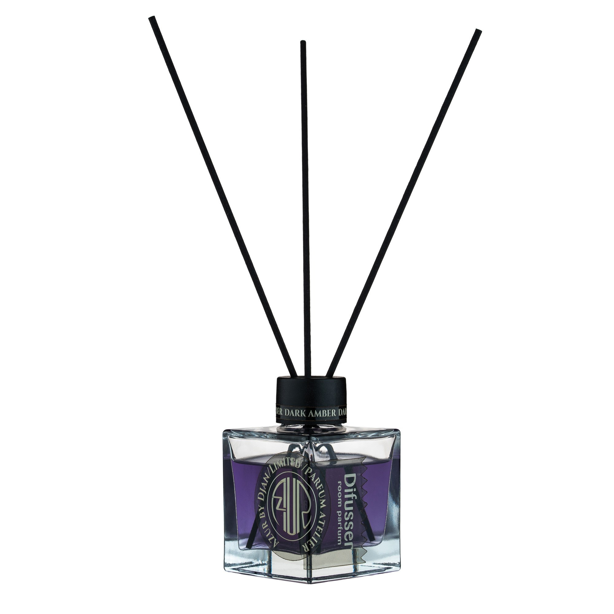 Ağ fonda, bənövşəyi maye ilə dolu şəffaf, düzbucaqlı otaq qoxusu diffuzoru. Qara çubuqlar və qapağın üstündə "DARK AMBER" və "Diffuser room parfum" kimi yazılar görünür.