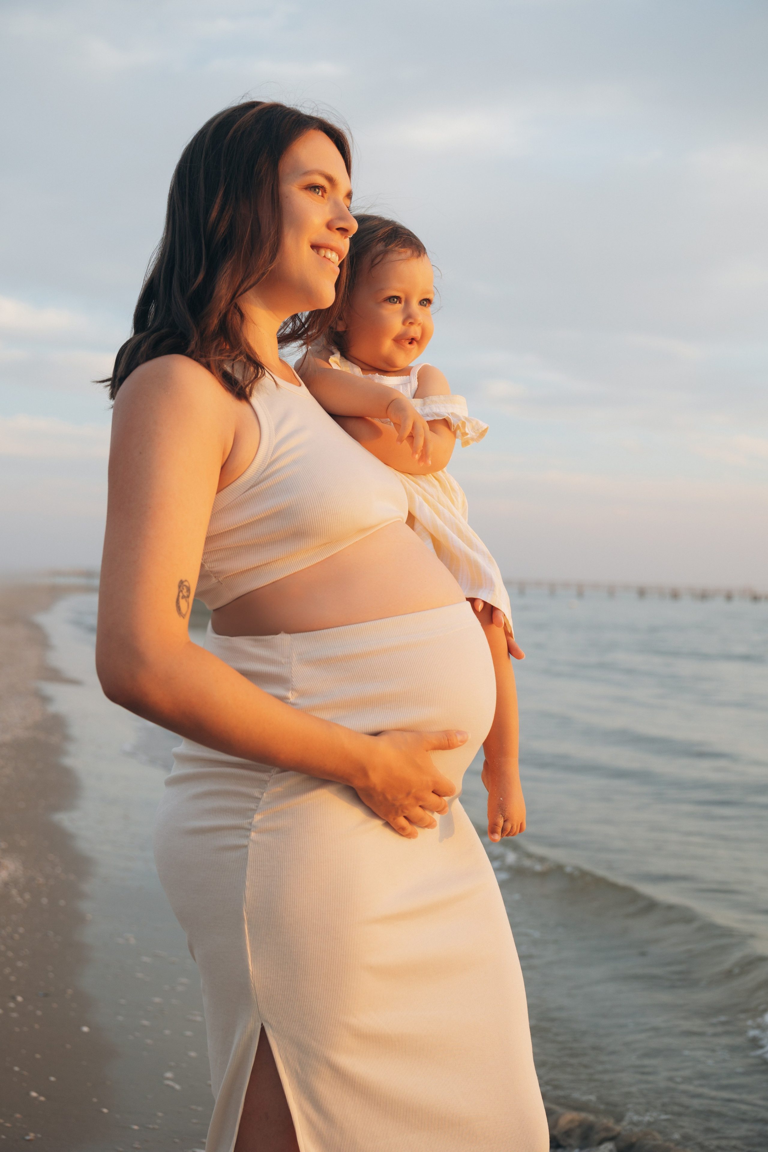 Ritratto maternità sulla spiaggia di Rimini con luce dorata.