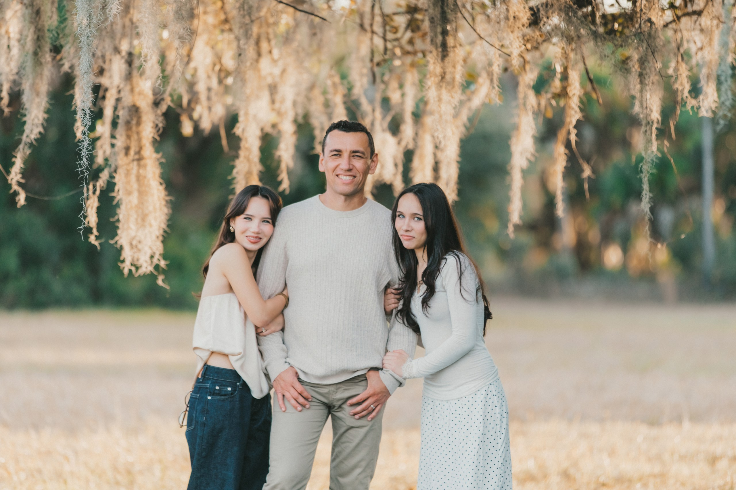 Father hugging her two daughters, authentic family moments photography in Florida.