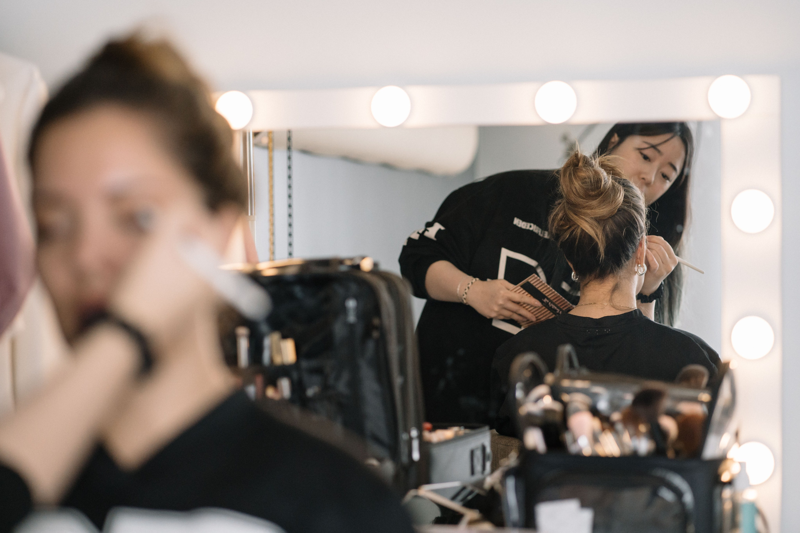 Woman receiving professional makeup application before luxury portrait session at Burnaby photography studio