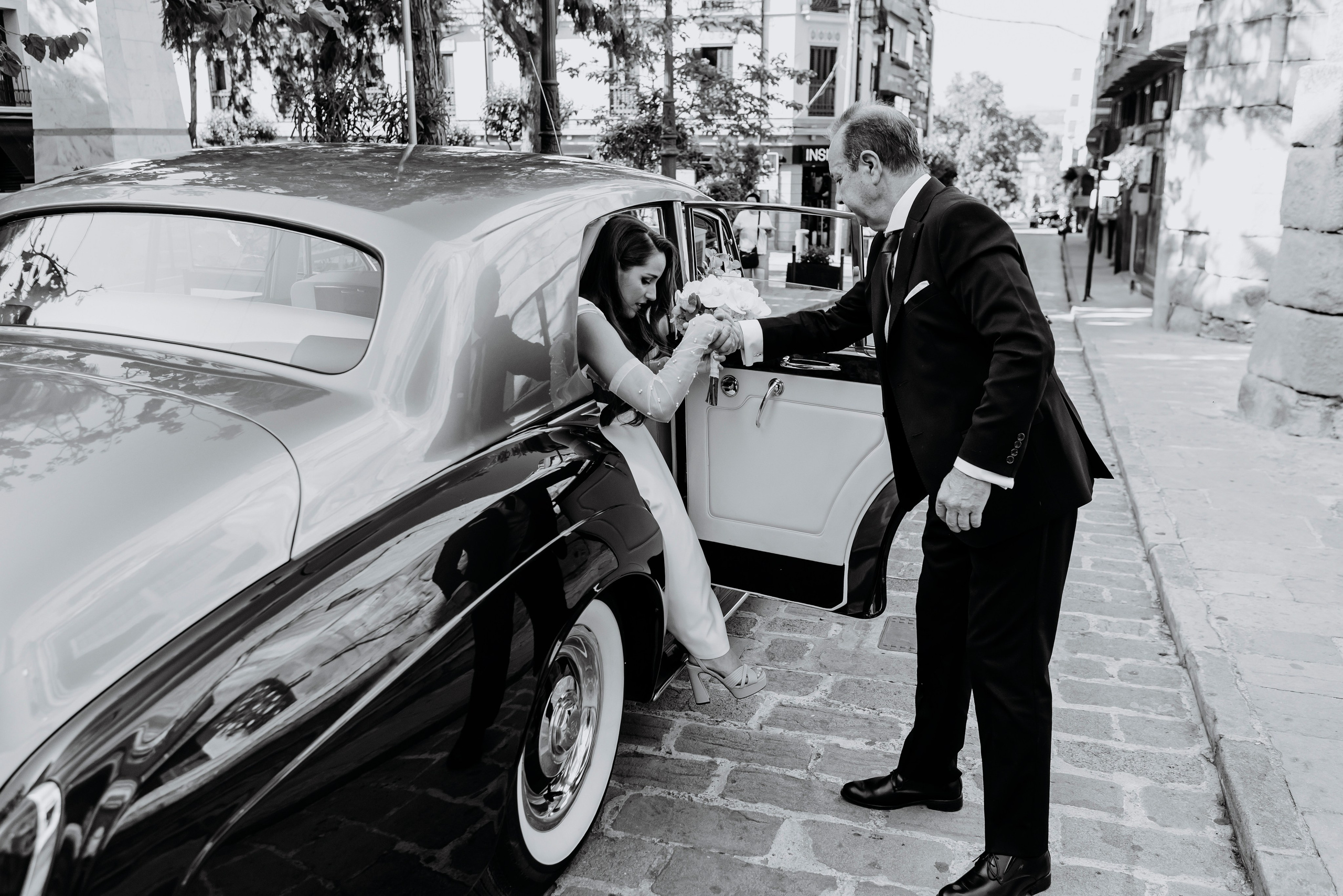 La novia bajando del coche y ayudada por su padre. Uno de los momentos más emocionantes de la boda