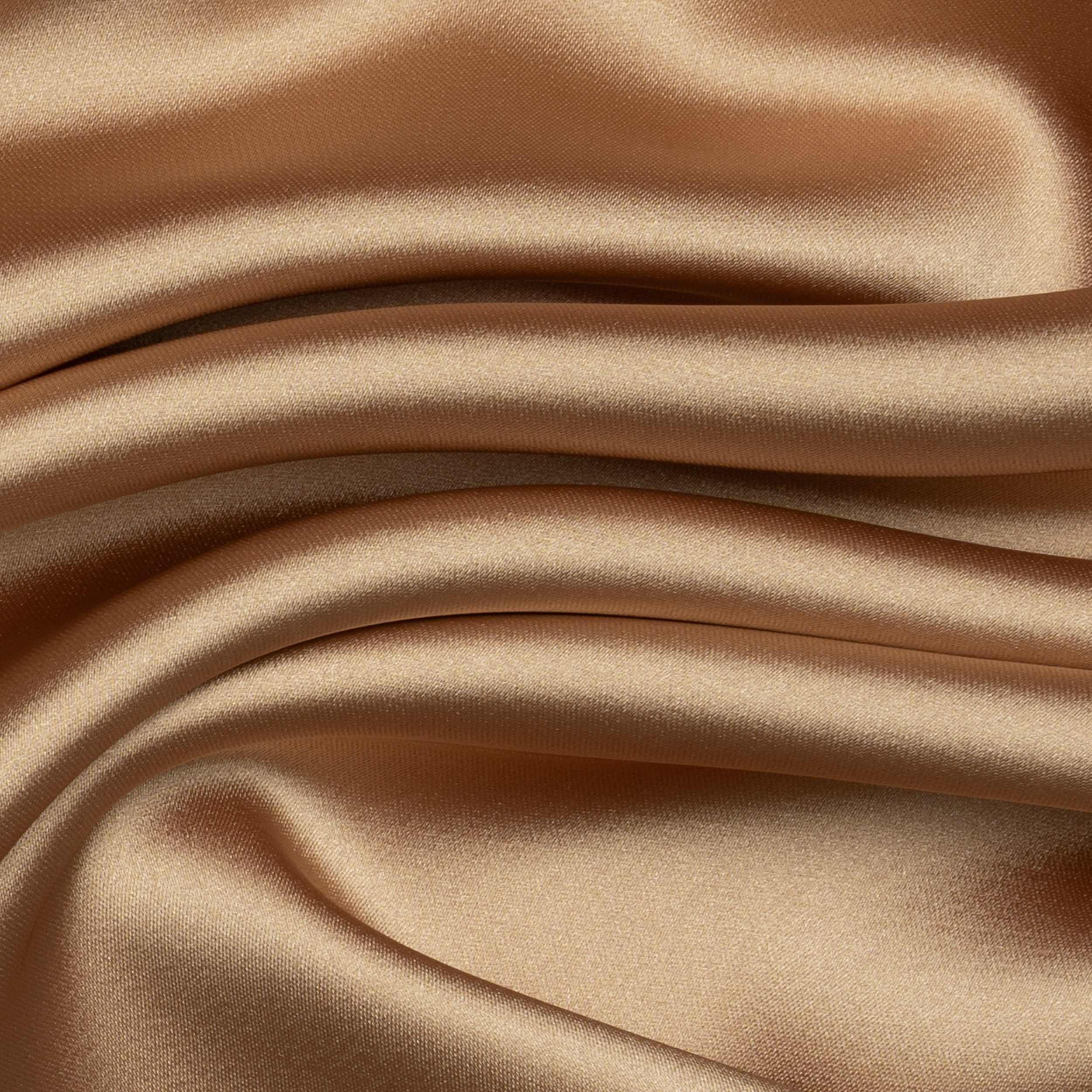 Close-up of smooth golden satin fabric with flowing folds