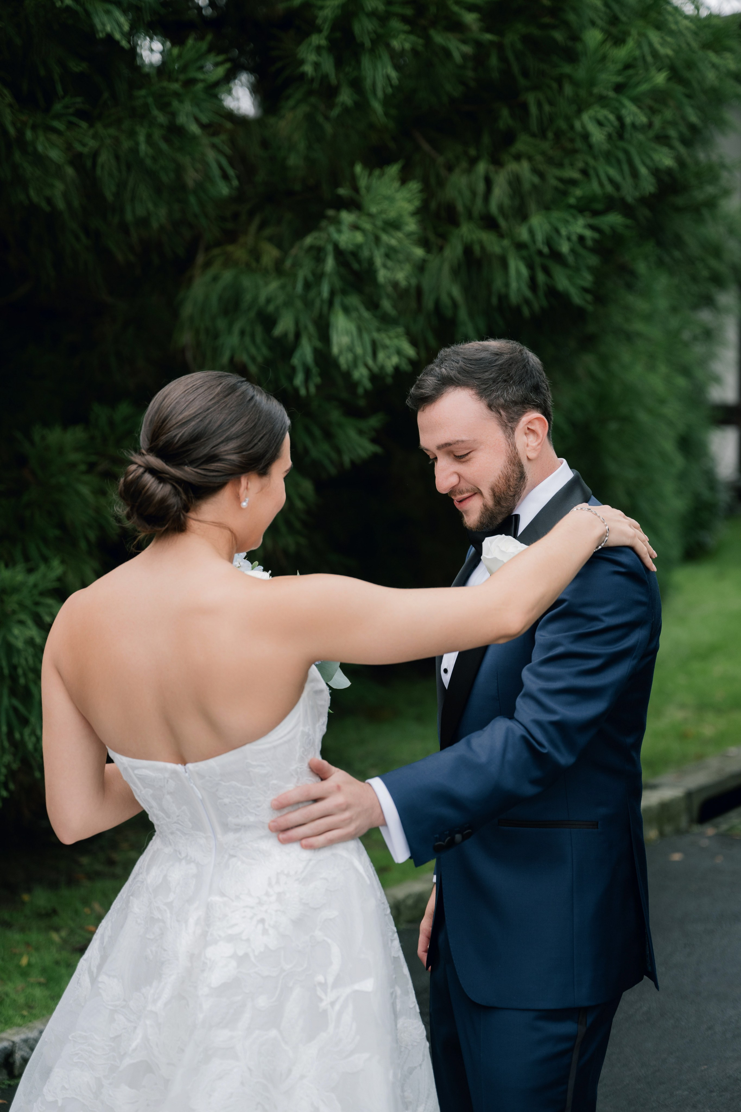 a bride and groom are standing in front of a tree