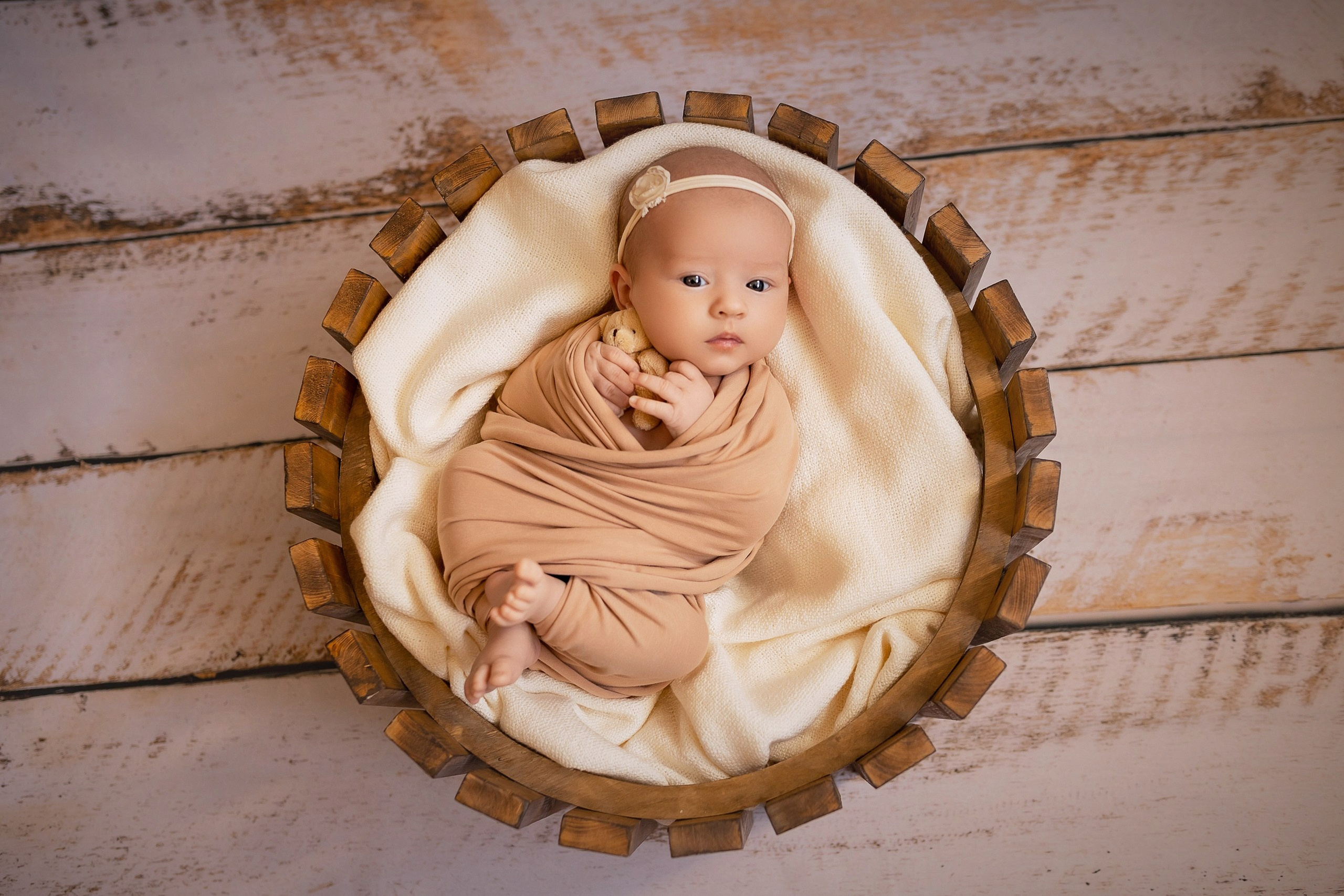 Newborn baby girl awake in rustic wooden basket