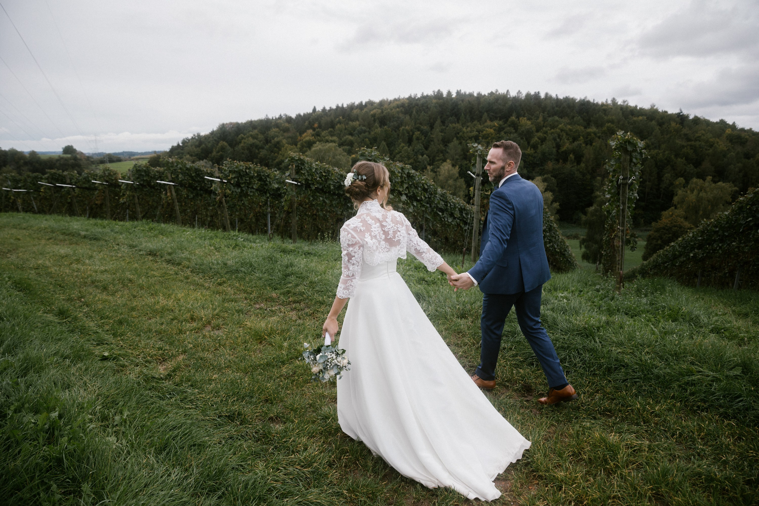 Braut führt Bräutigam durch den malerischen Weinbergspfad in Markdorf