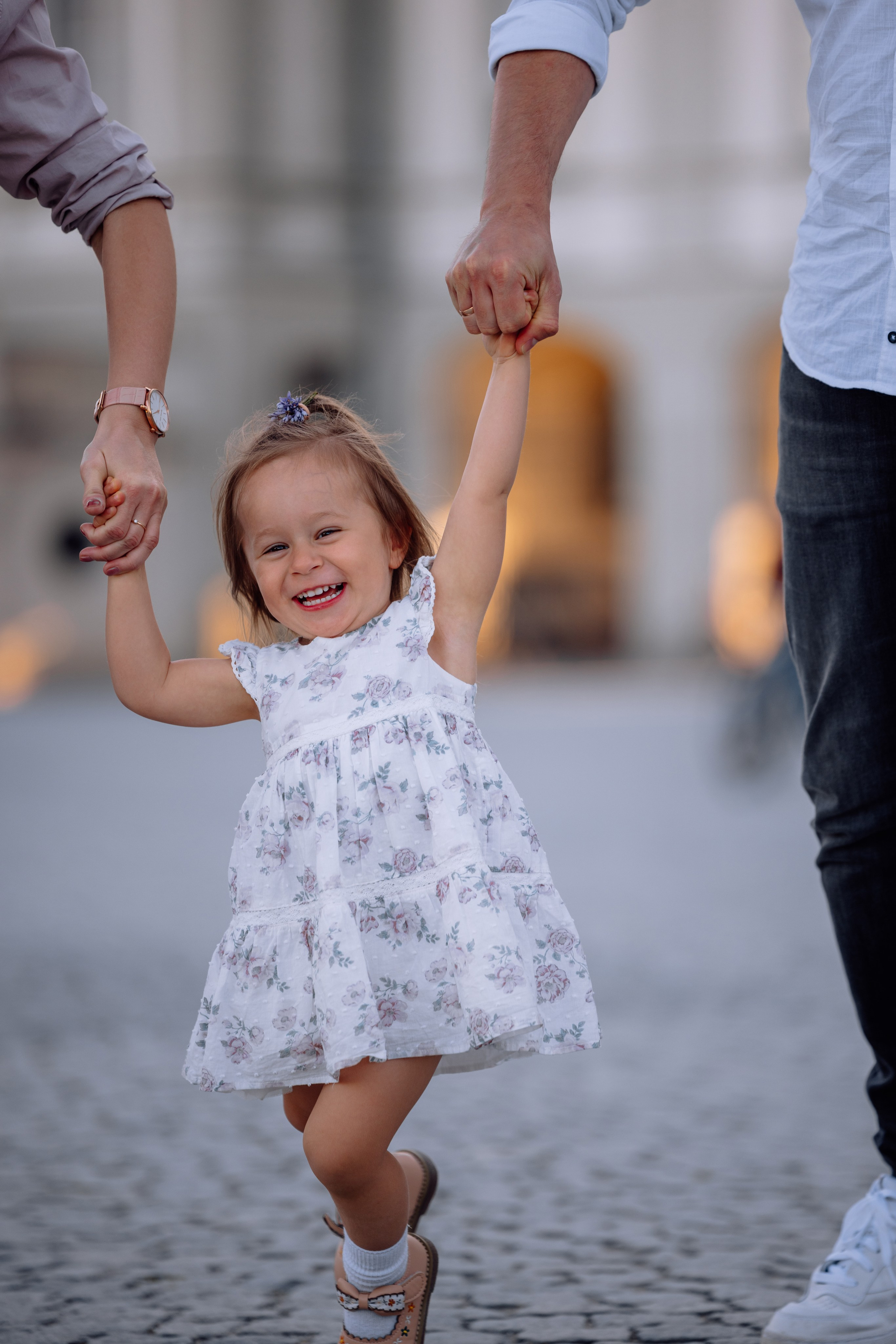 Kleine Tochter springt fröhlich beim Familienfotoshooting in München