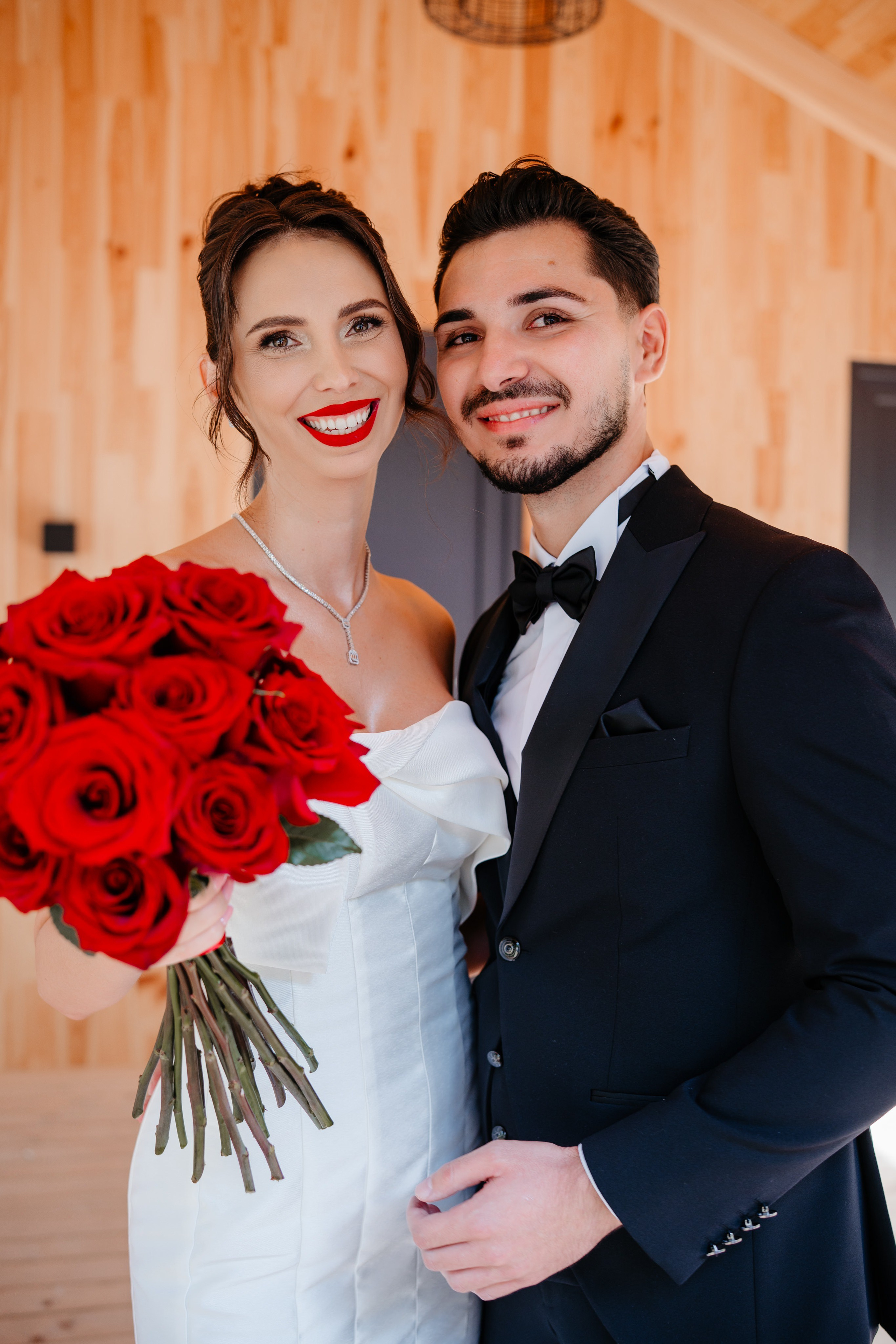 Portret oficial de nuntă cu mirii în fața locației de la munte.