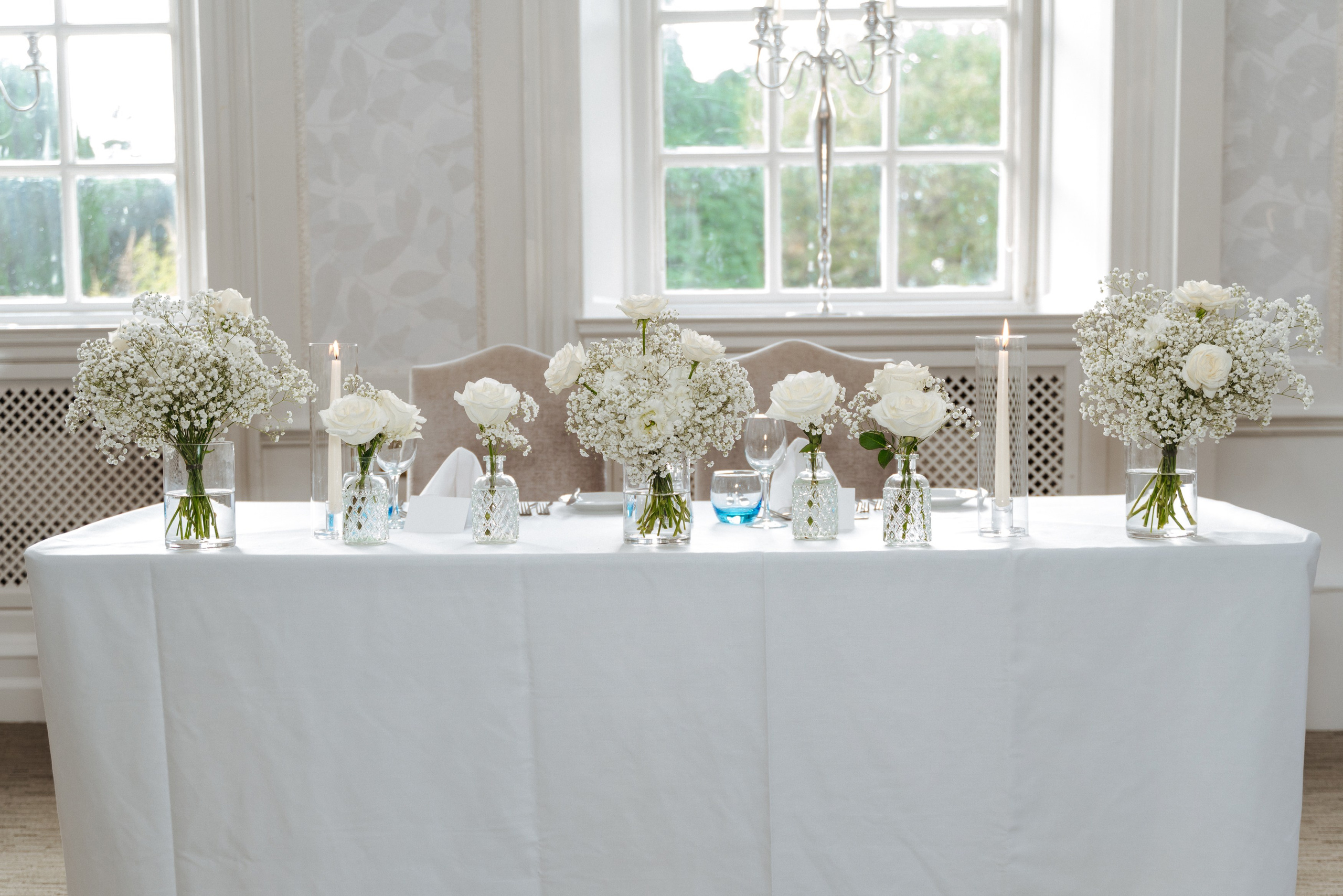 Wedding table details at Barnet Hill Hotel, featuring white floral centrepieces, elegant place settings and gold cutlery.