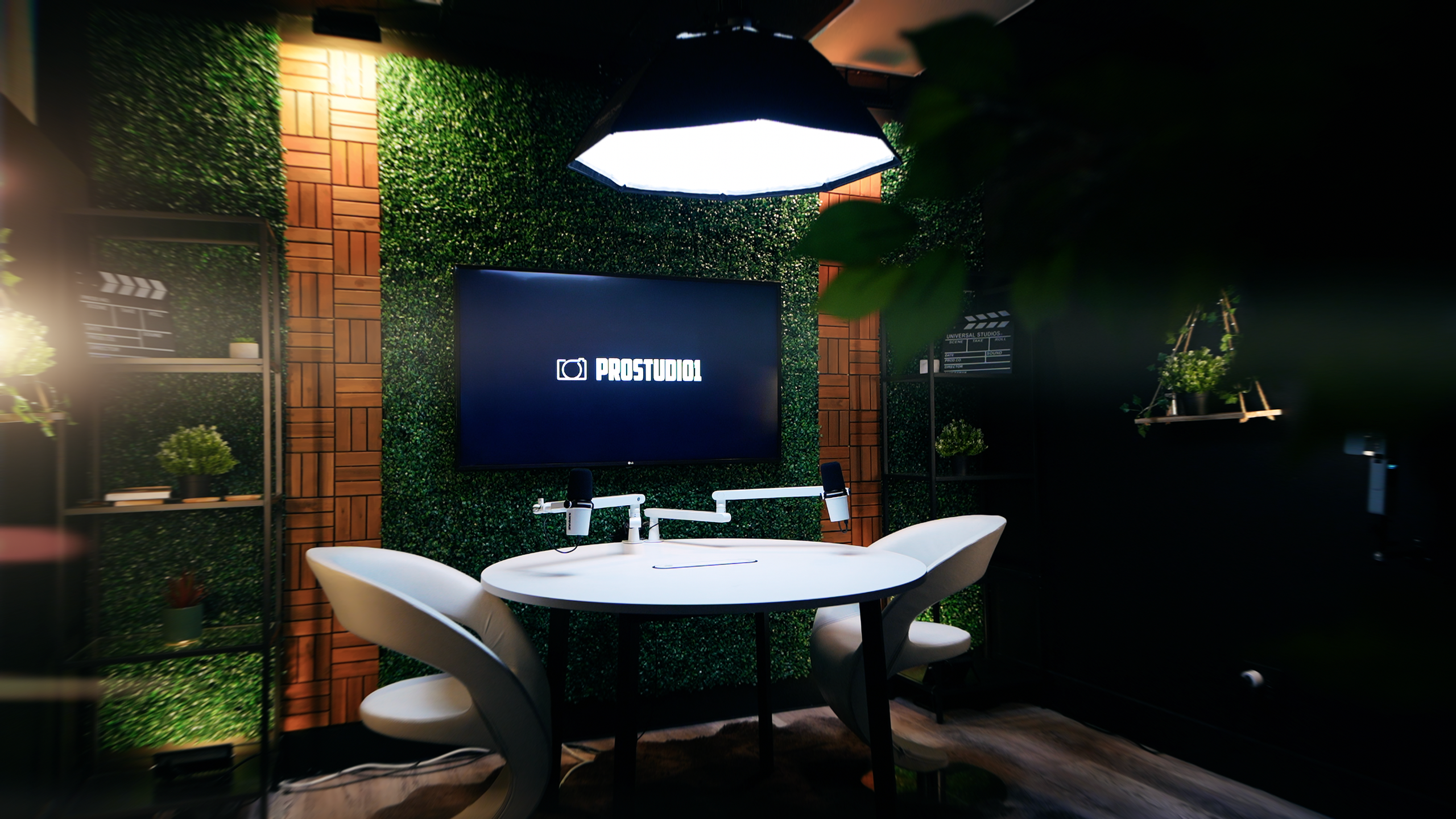 Podcast recording table with TV screen and studio lights at ProStudio1 Miami area