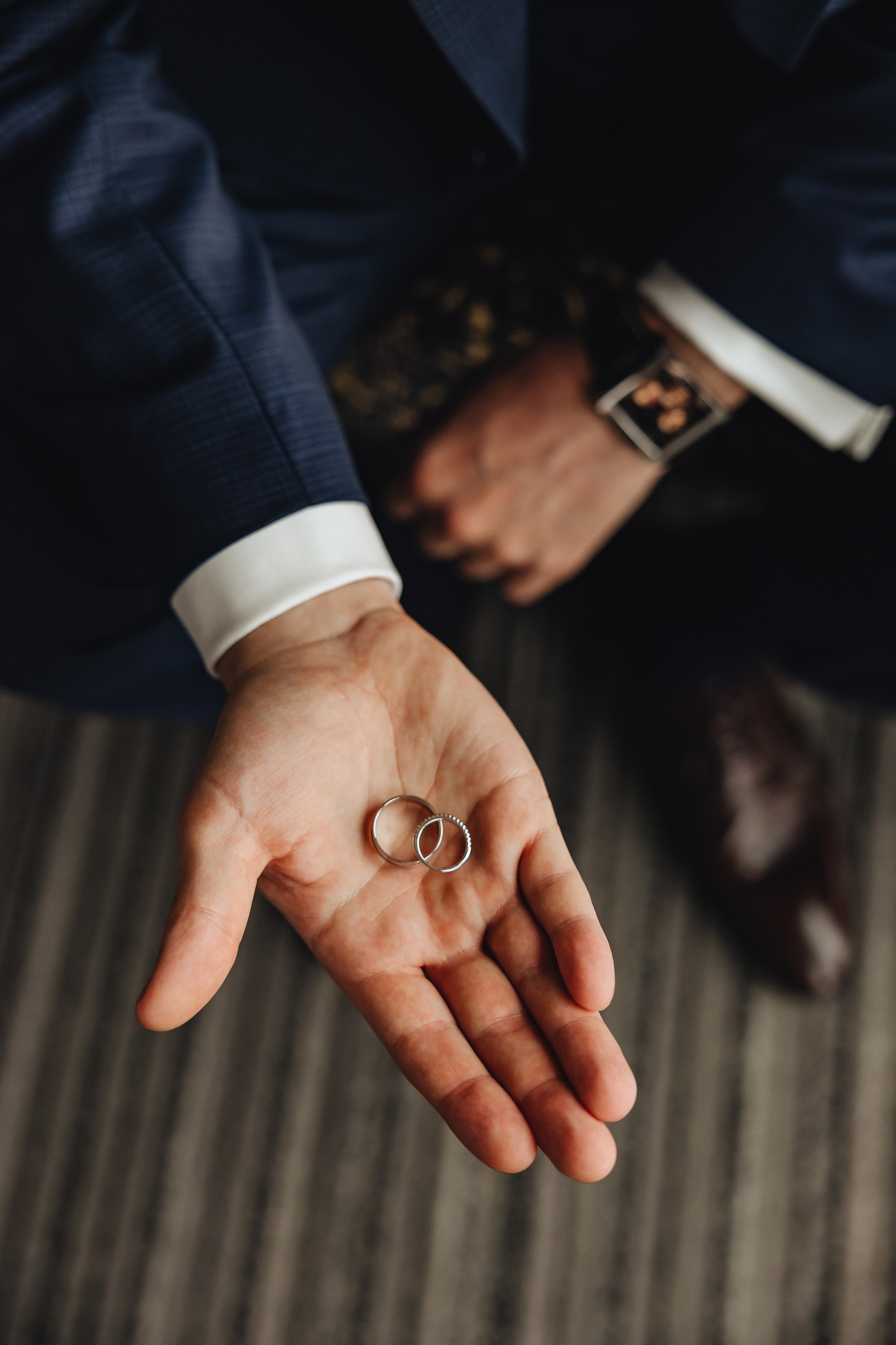 Eheringe in den Händen des Bräutigams – Hochzeitsfotografie mit Liebe zum Detail. Hochzeitsfotograf für emotionale Hochzeitsreportagen in NRW: Düsseldorf, Bochum, Dortmund, Essen, Duisburg, Wuppertal, Krefeld, Münster, Köln, Bonn, Aachen. Traumhafte Hochzeiten in Schloss Nordkirchen, Schloss Dyck, Schloss Hugenpoet, Schloss Rheydt, Schloss Wickrath und weiteren exklusiven Locations.