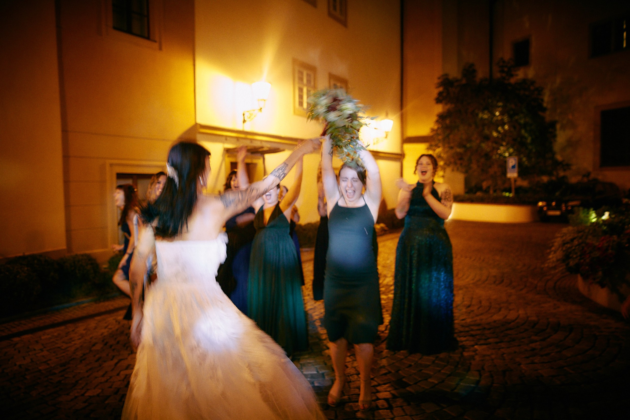 Guest celebrating bouquet win overhead.