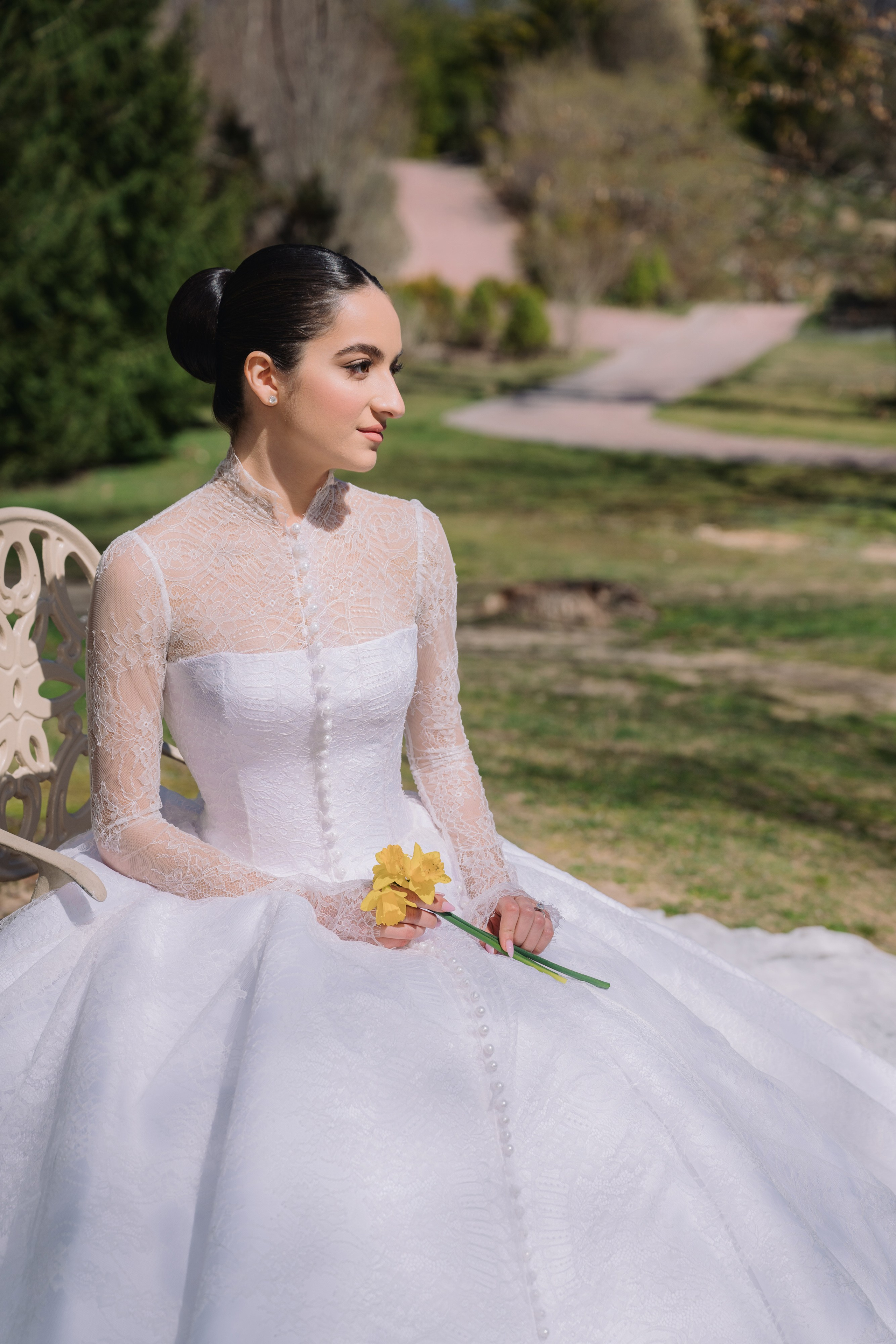 a woman in a white wedding dress sitting on a bench