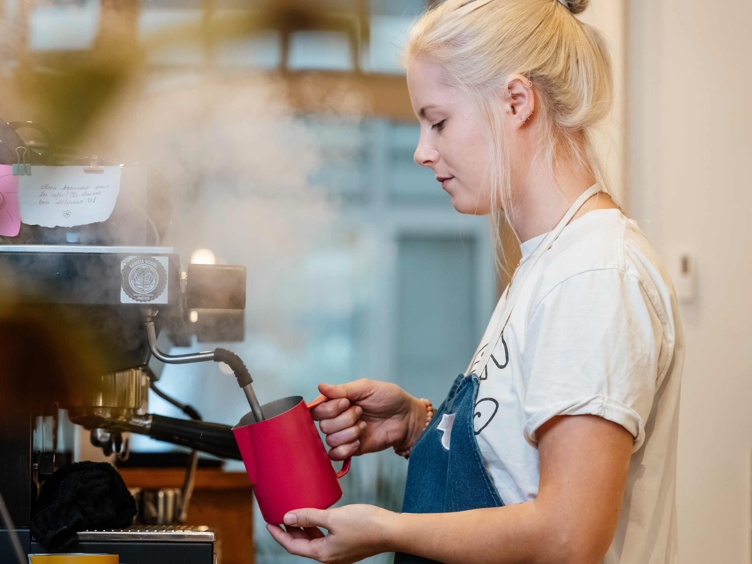 Barista profesionist preparând cafea de specialitate într-o cafenea modernă, fotografie comercială pentru branding horeca