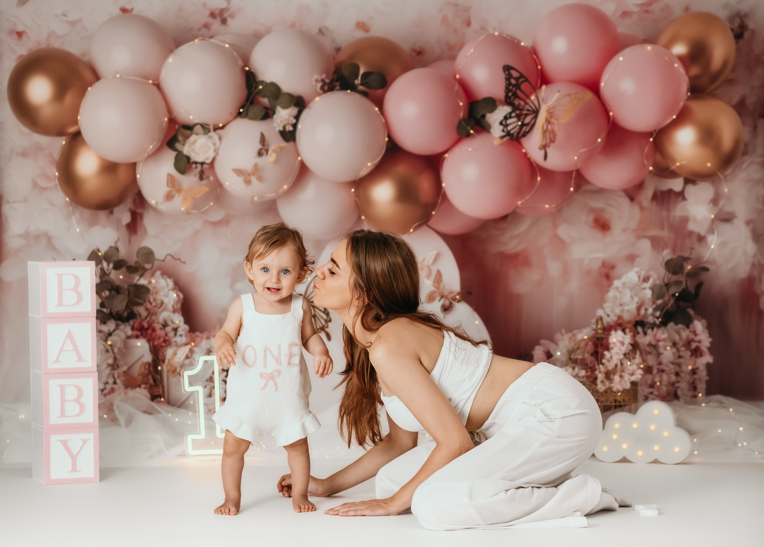 Cake smash Beograd – devojčica sa tortom i dekoracijom roze balona